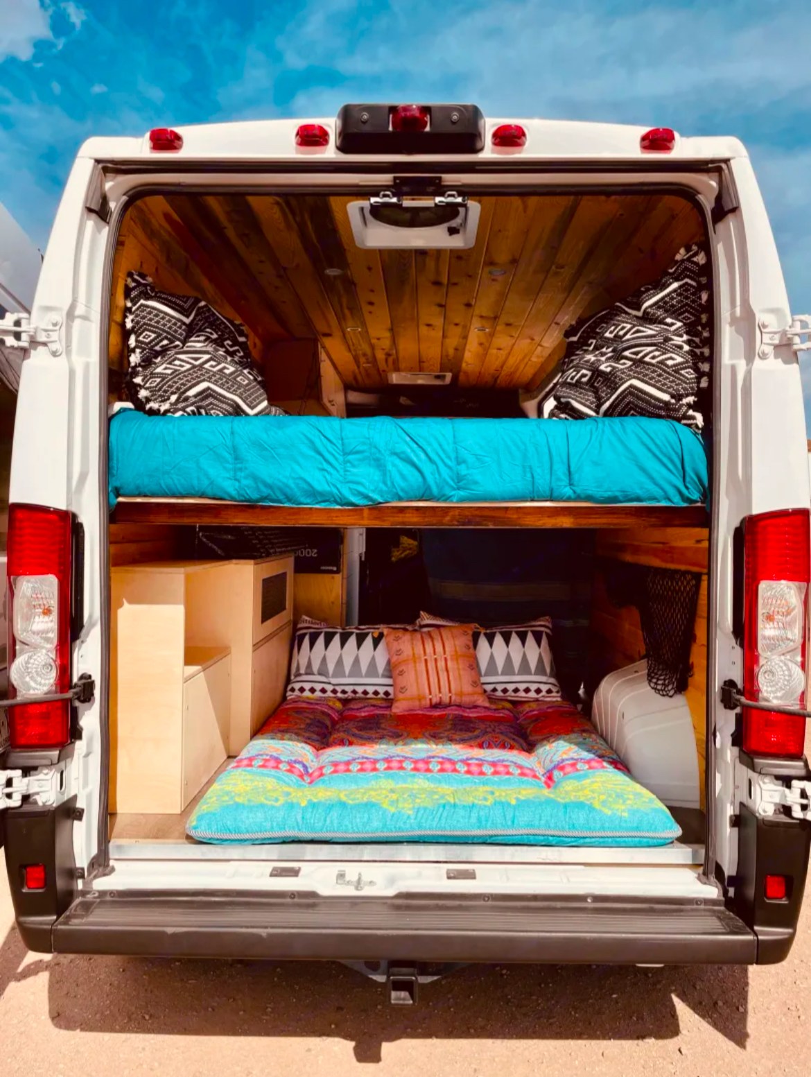 Rear view of an RV rental: two beds, custom wood ceiling, cabinetry. Ideal for road trips, offering comfy mobile living.. Dodge Ram Promaster 2500 2021