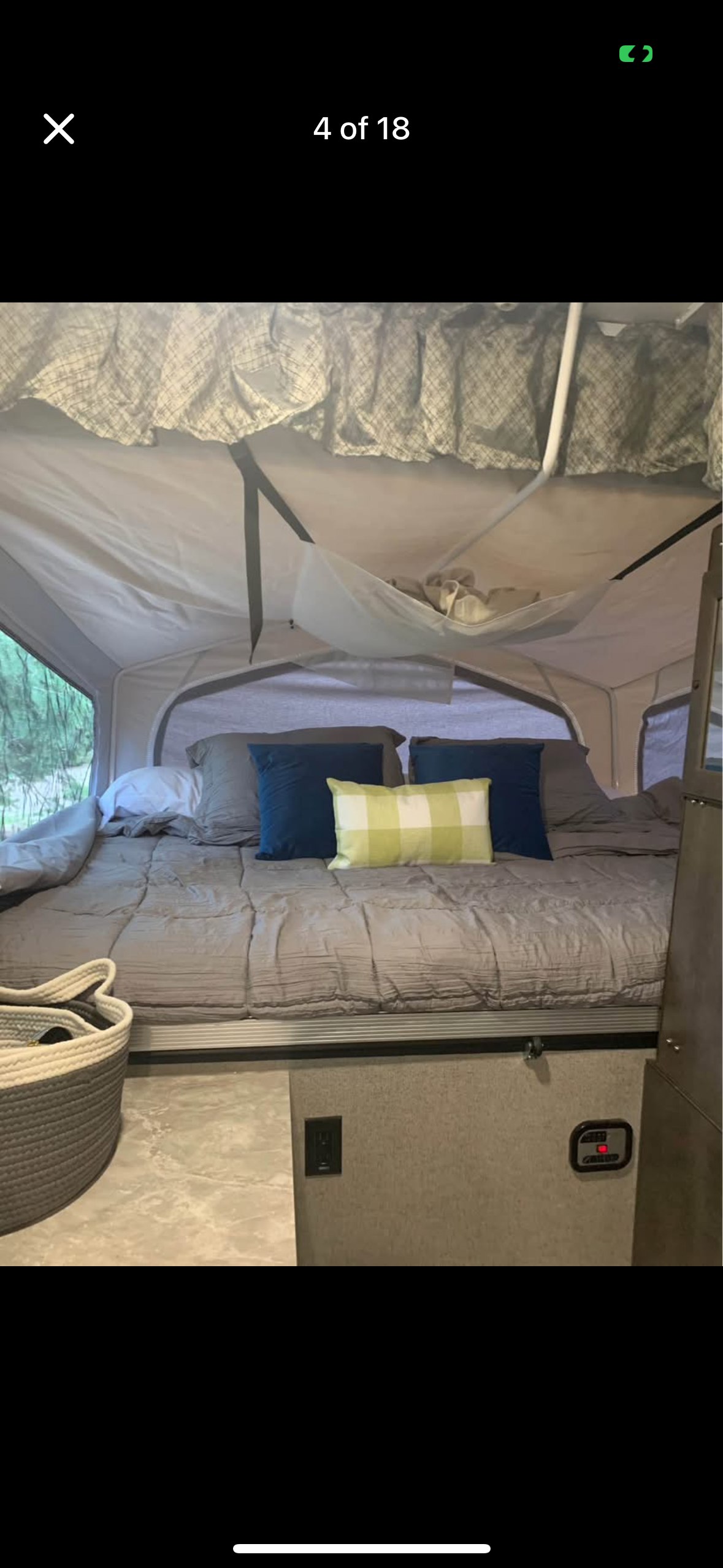 Inside this RV rental: A comfortable pop-up camper bedroom with a bed, pillows, and storage netting.. Forest River Rockwood Premier 2020