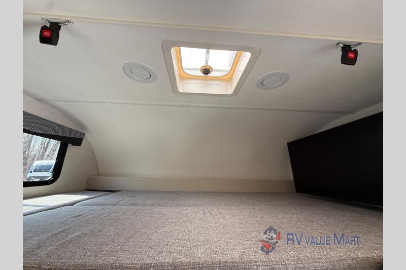 RV rental interior: a comfortable bunk bed area with window, ceiling skylight, vents, TV, and safety latches.. Thor Motor Coach Four Winds 2026