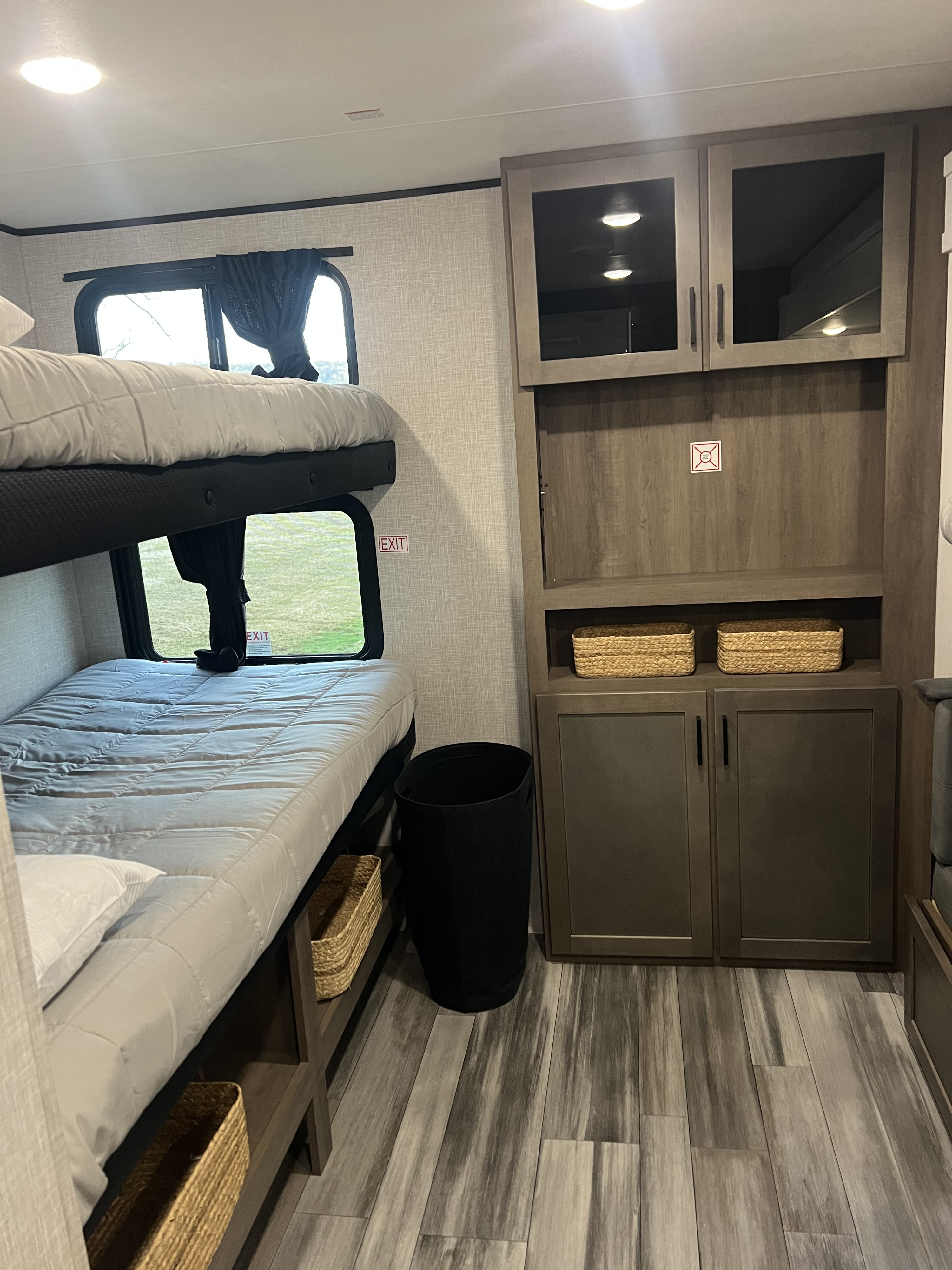 RV rental bunk room with dual beds, clever storage solutions like baskets and cabinets, and wood-look flooring.. Jayco Jayflight 324bds 2025