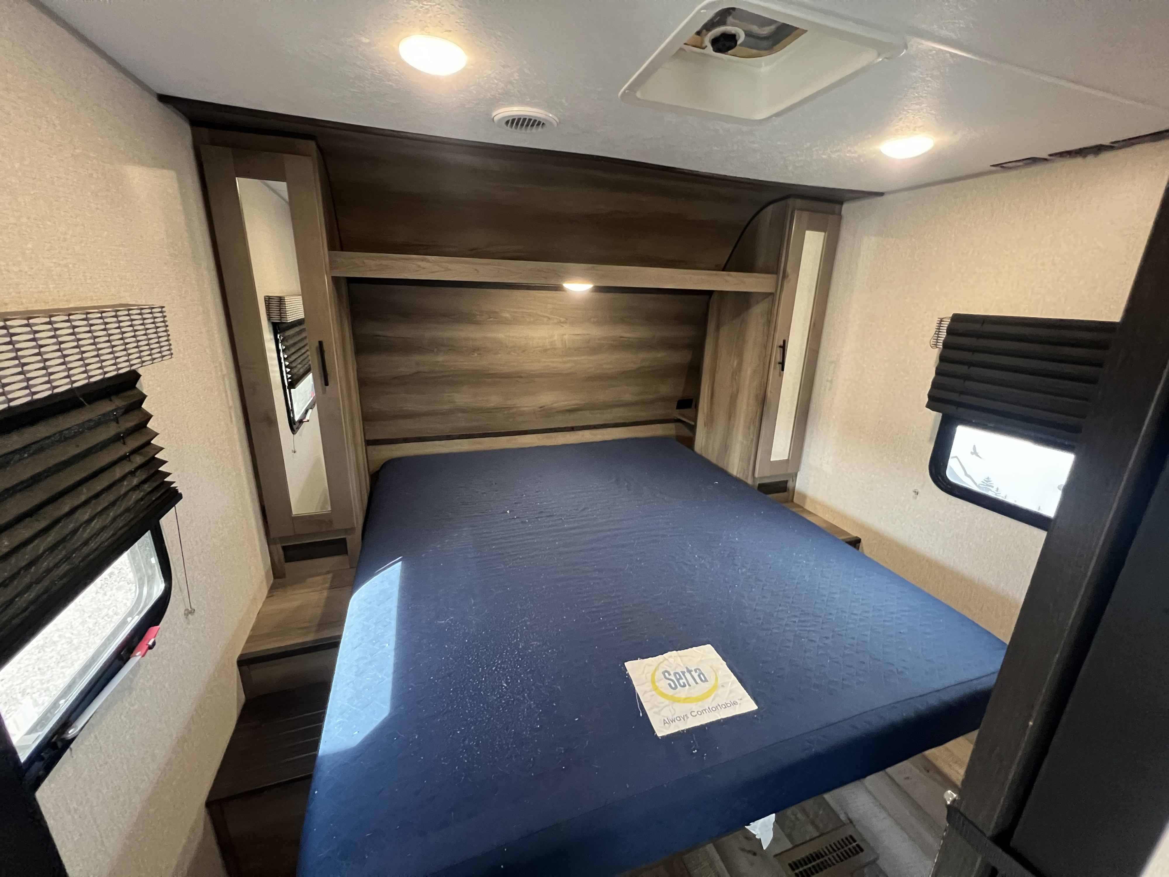 RV rental interior: A comfortable bedroom setup with a blue Serta mattress, built-in storage, and blinds.. KZ Confluence 2022
