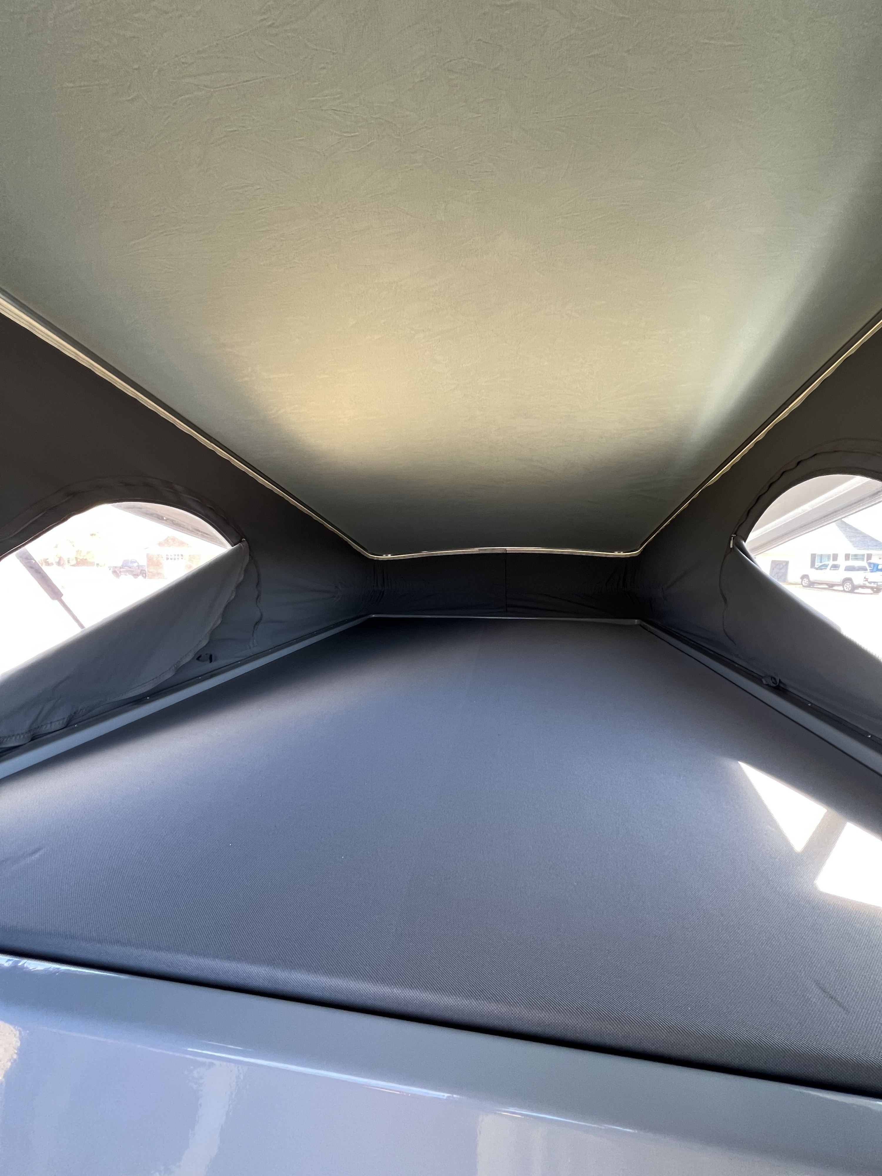 RV rental interior: Light fabric pop-up roof, mesh windows, and a large dark sleeping platform in this camper.. Winnebago Solis 2022