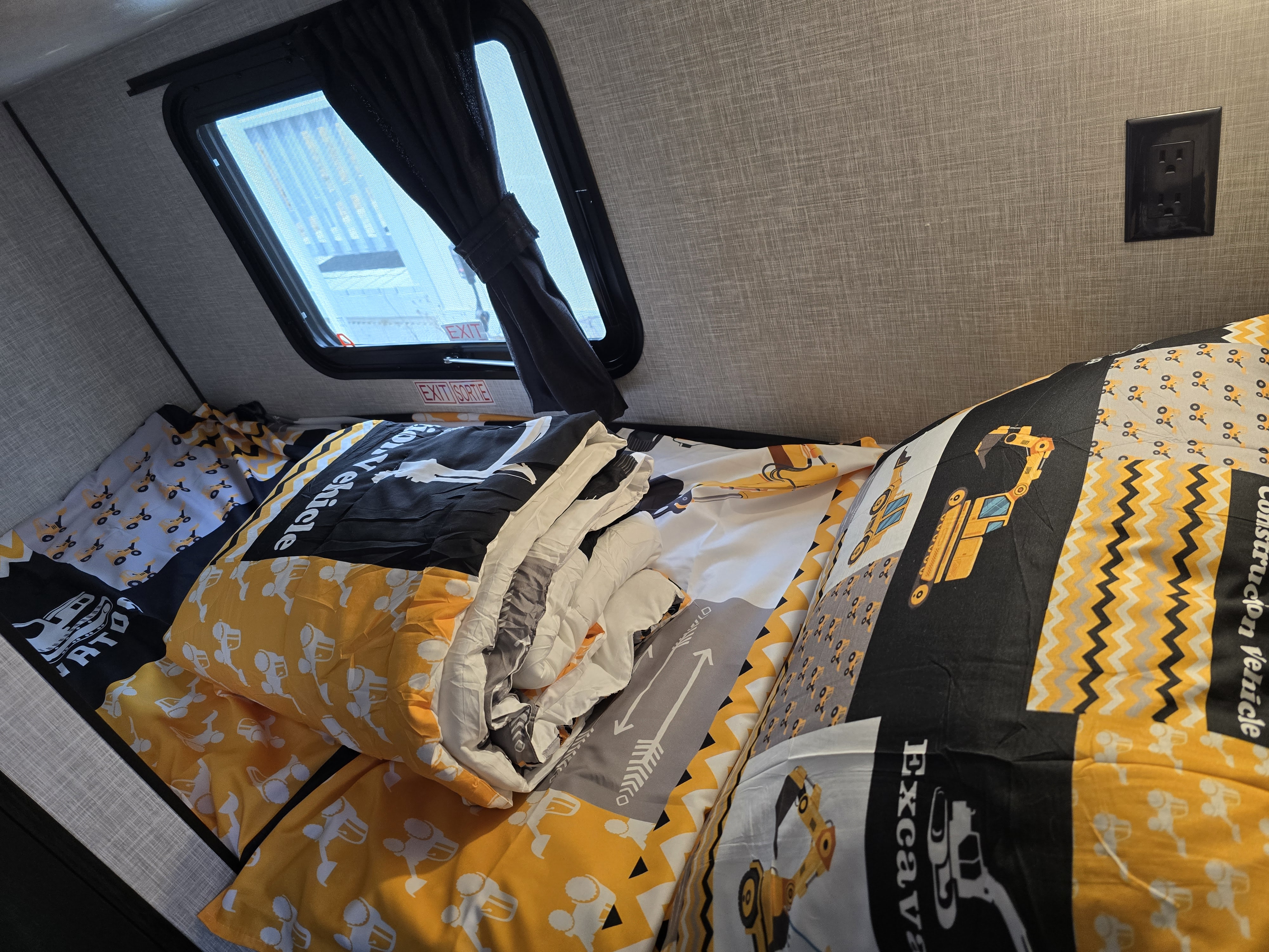Cozy RV rental bunk with construction vehicle bedding, window & outlet. Ideal for family adventures.. Jayco Jay Flight SLX 2024