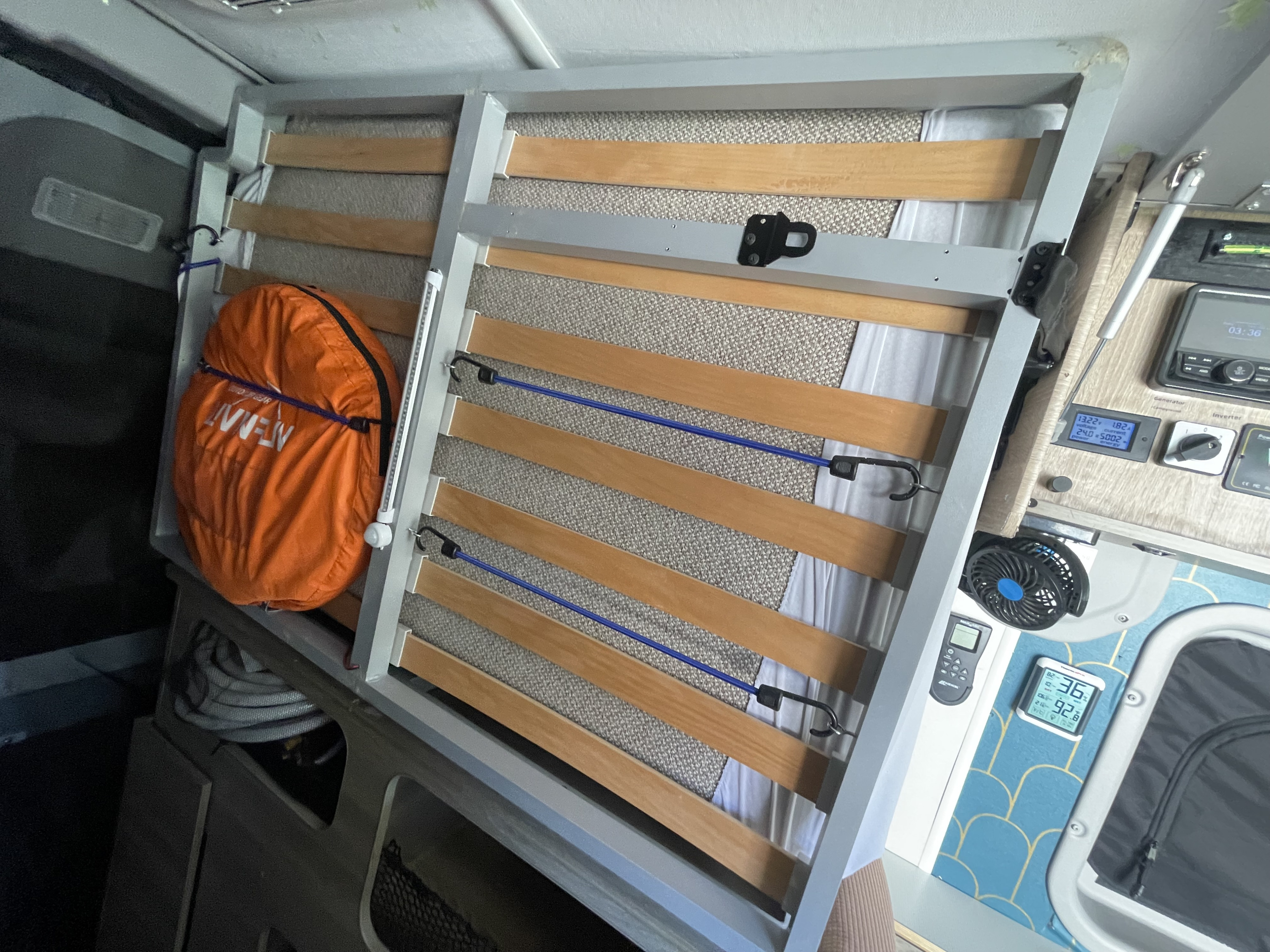 RV rental camper van: Tilting bed frame shows under-bed storage, controls for power and temperature, plus a fan.. Winnebago Solis Pocket 2022