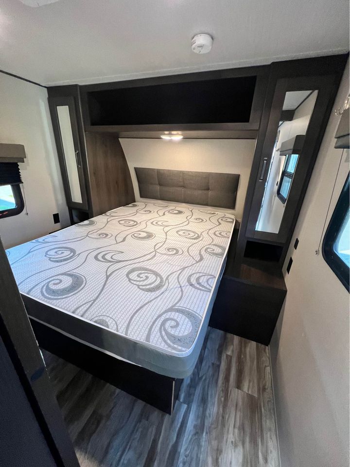 Compact, comfortable RV rental bedroom with ample storage & patterned mattress. Ideal for travel.. Grand Design Transcend Xplor 2021
