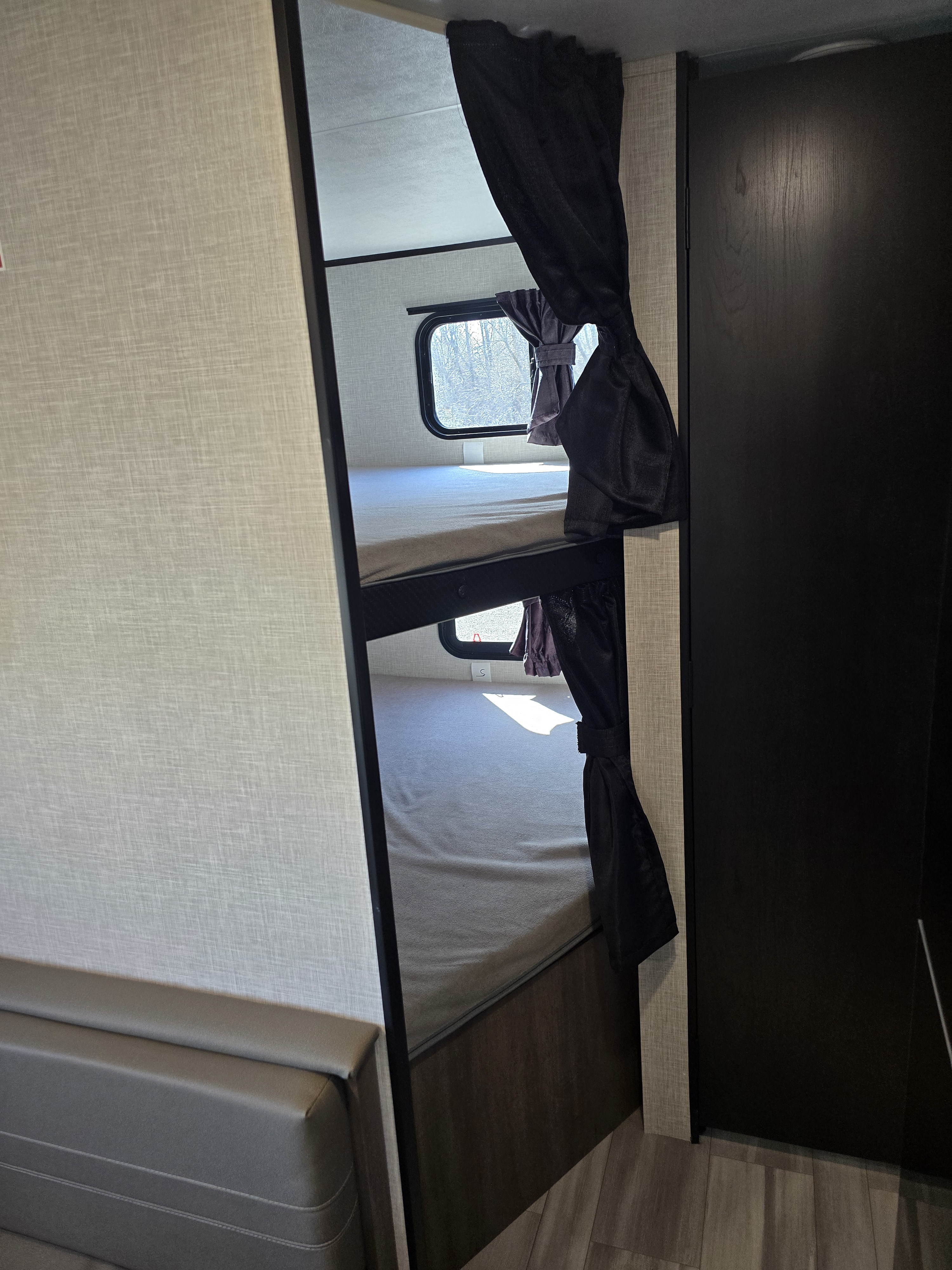 Cozy bunk beds with privacy curtains inside an RV rental, offering comfortable sleeping arrangements.. Starcraft Autumn Ridge 26BH 2025