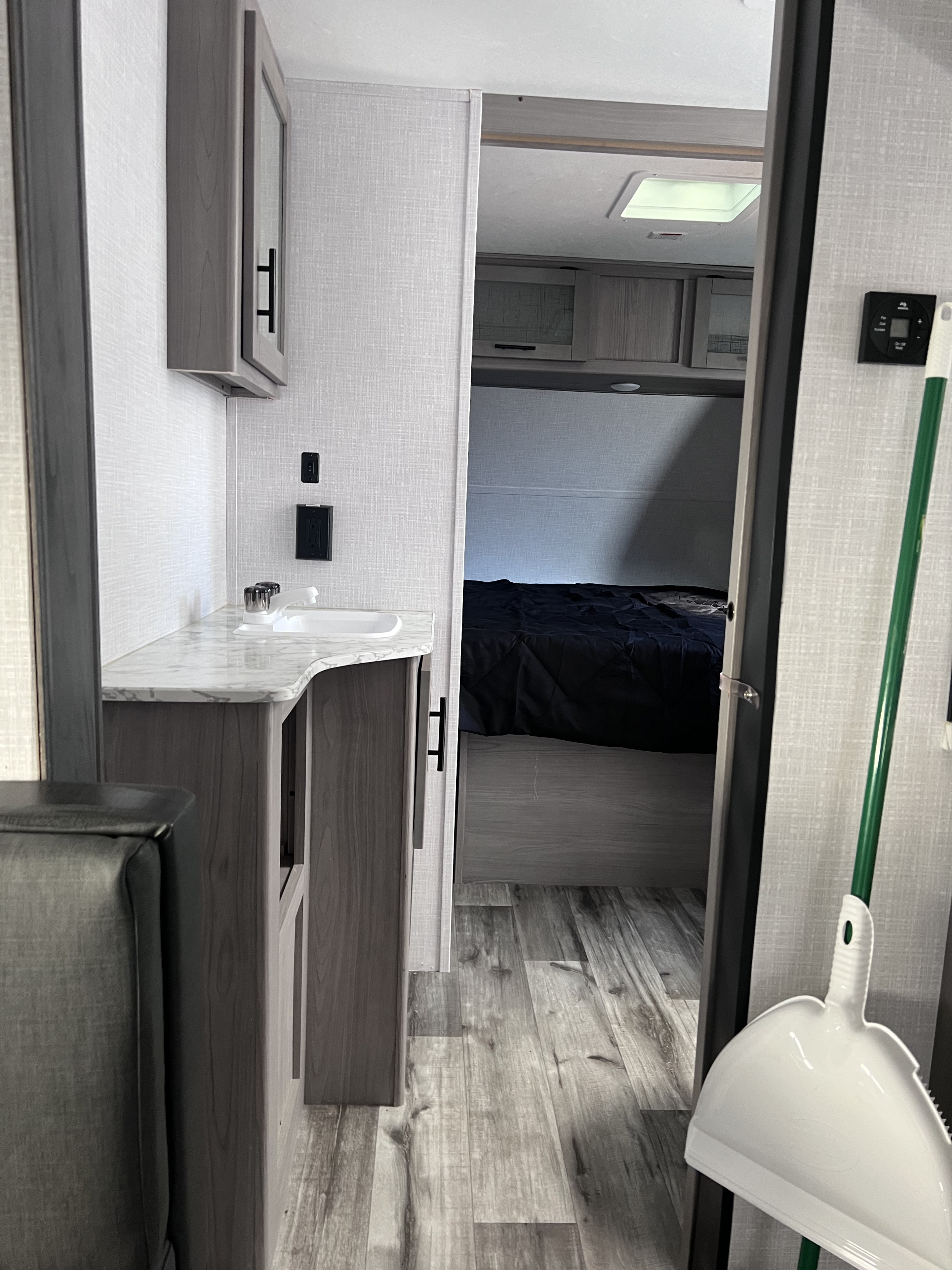 Explore this RV rental's interior: a compact vanity with sink leads to a cozy bedroom. Ideal for your next road trip!. Coleman 3215BH 2022