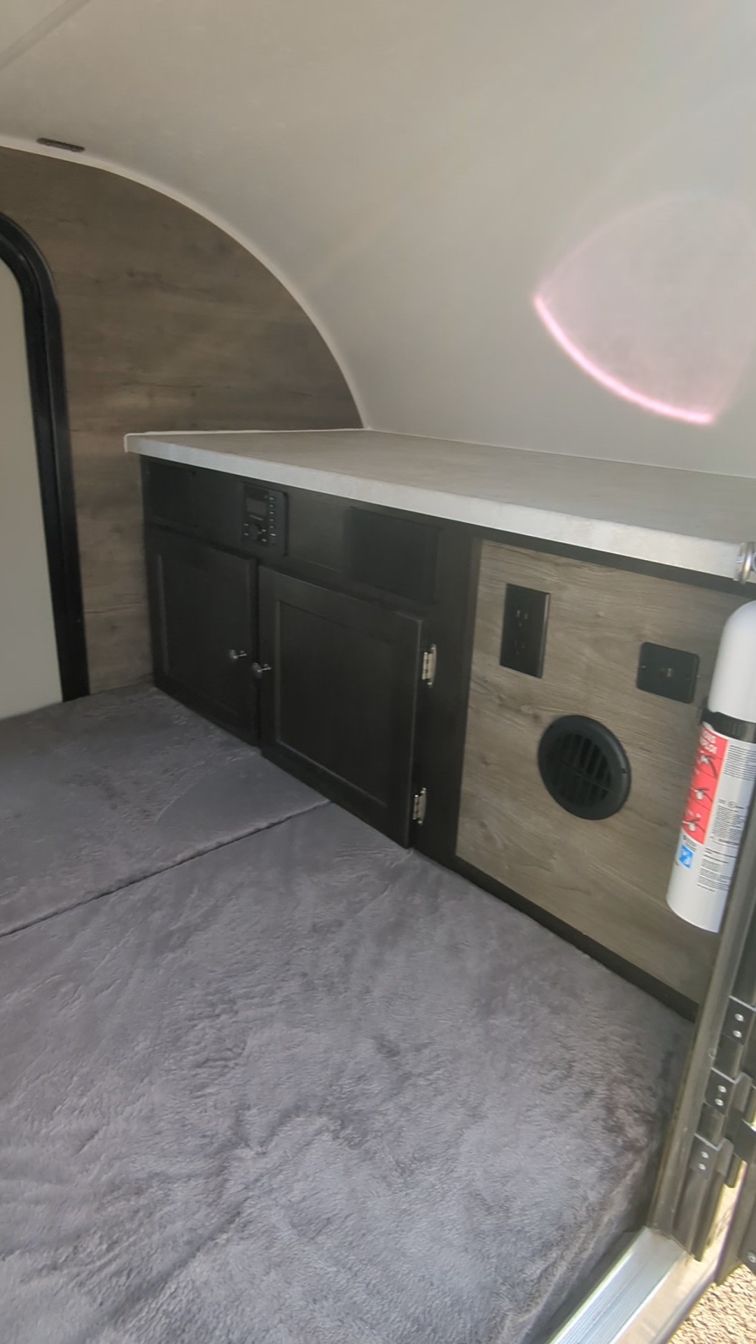 Discover this RV rental's interior: plush grey bed, cabinets, stereo, power outlets, and a vent. Fire safety included.. Braxton Creek Bushwhacker 2023