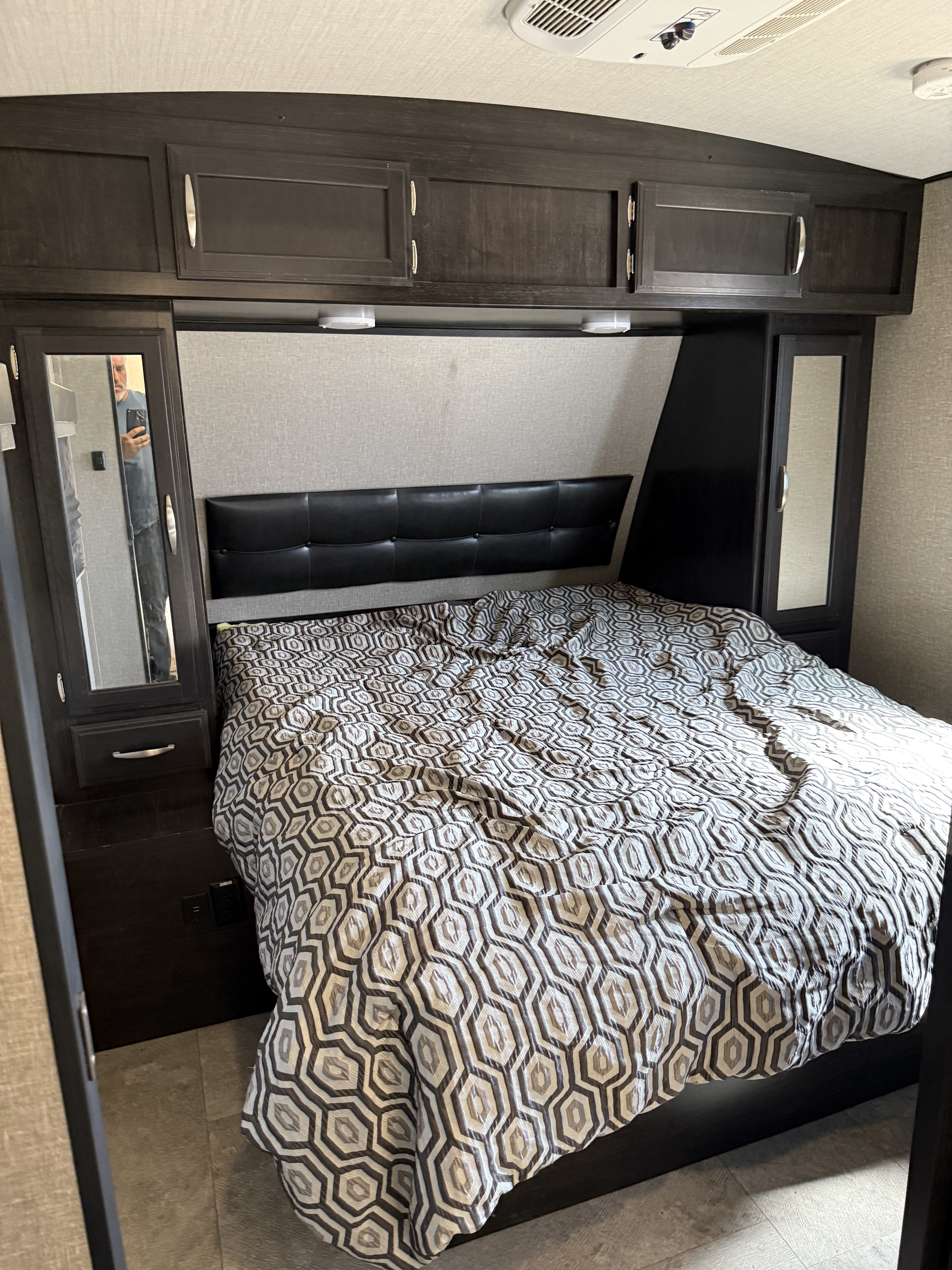 This RV rental offers a comfortable bedroom with a queen bed, stylish comforter, ample overhead storage, and mirrored closets.. Grand Design De Imagine 2019