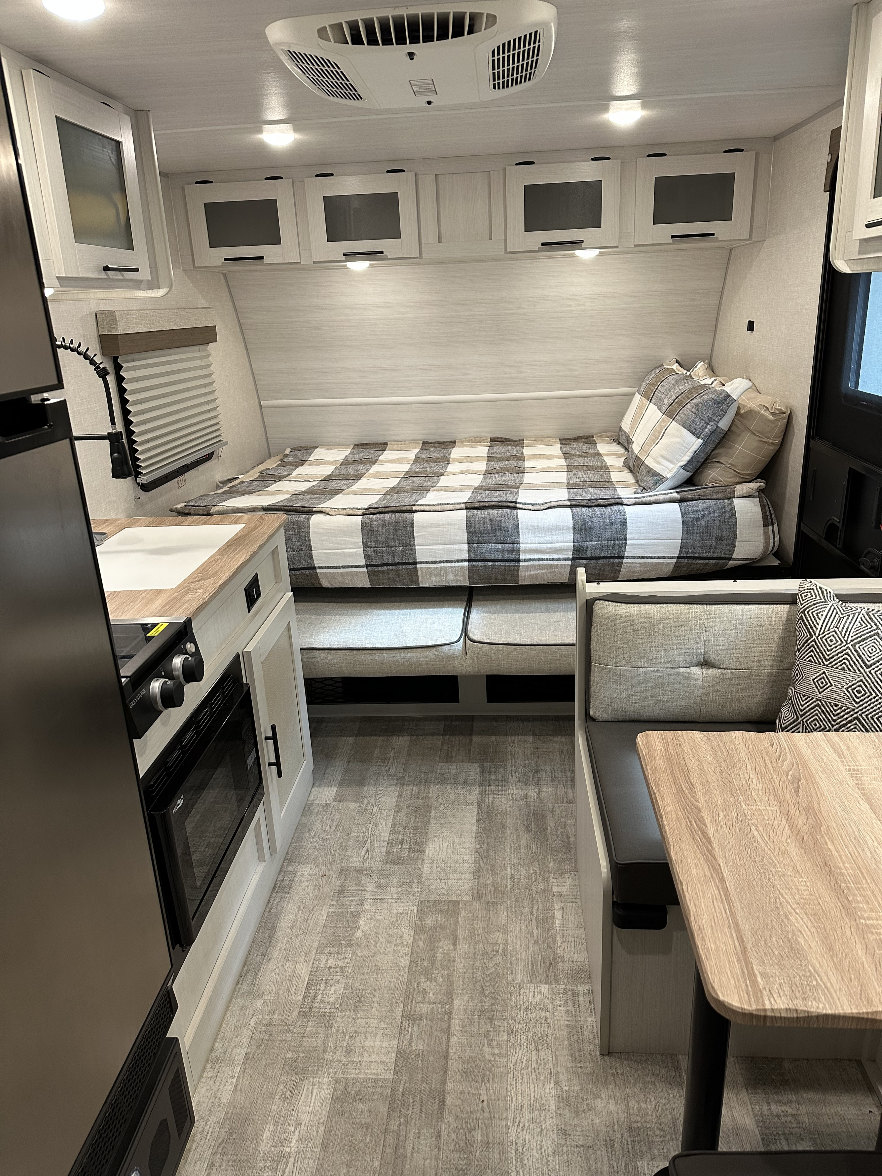 Experience comfort in this rv rental. View of bedroom, galley kitchen with microwave, and dinette space.. No Boundaries 19.3 EO 2024