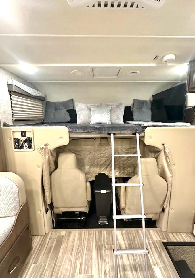 RV rental: Cab-over bunk with TV & ladder. Driver/passenger seats below. Cozy motorhome interior for road trips.. Thor Freedom Elite 2021