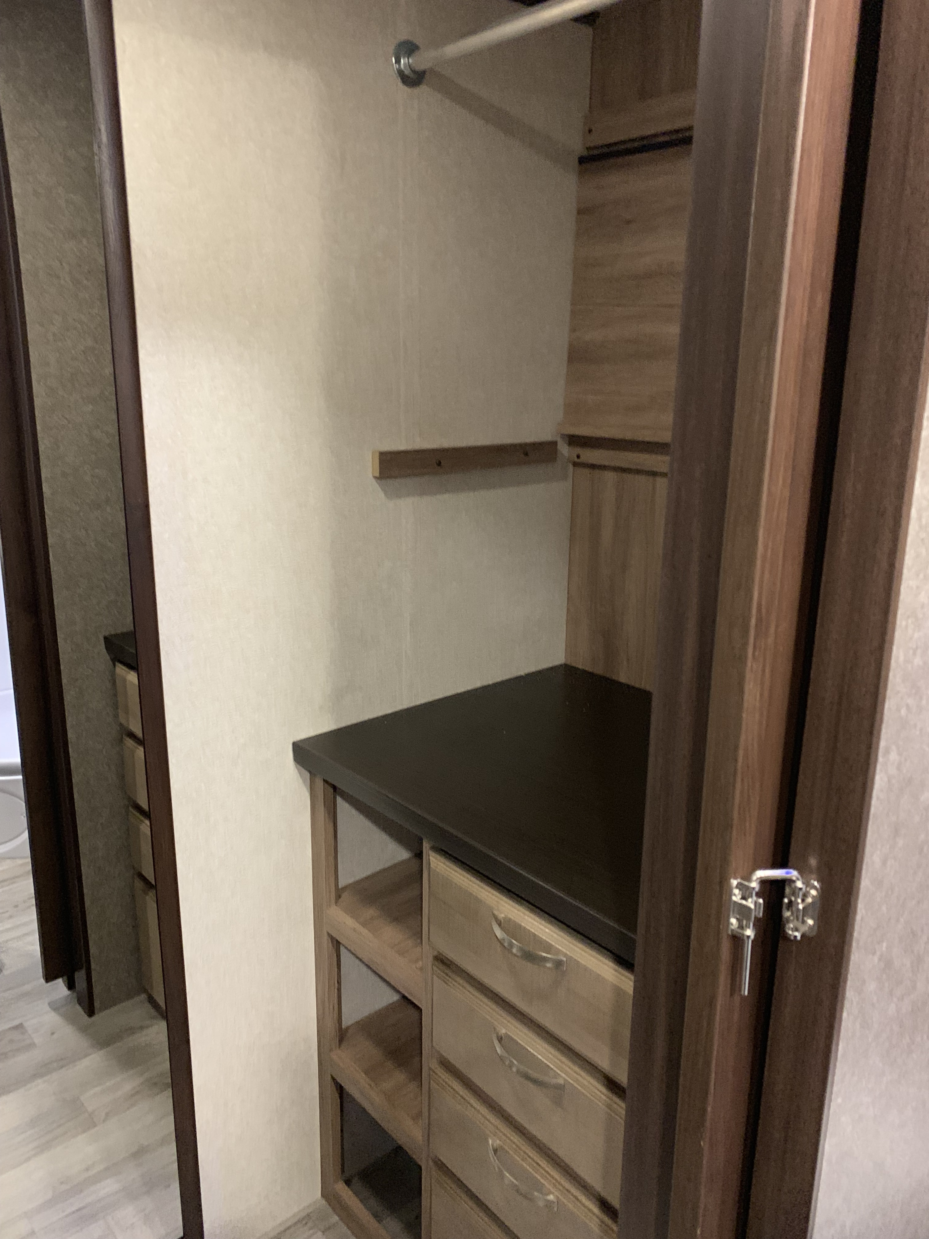 RV rental storage: A compact closet with hanging rod, drawers, and open shelving for efficient organization.. Jayco White Hawk 2020