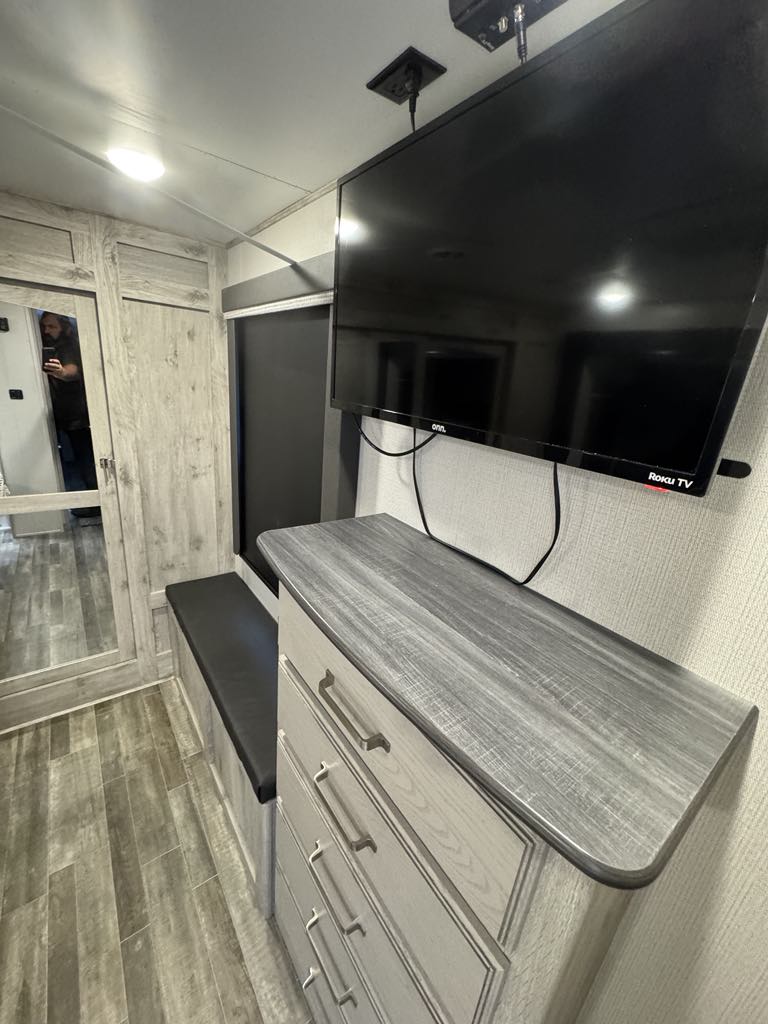 RV rental bedroom: Modern interior with mounted TV, dresser, and built-in bench for comfort & storage.. Keystone RV Avalanche 2022