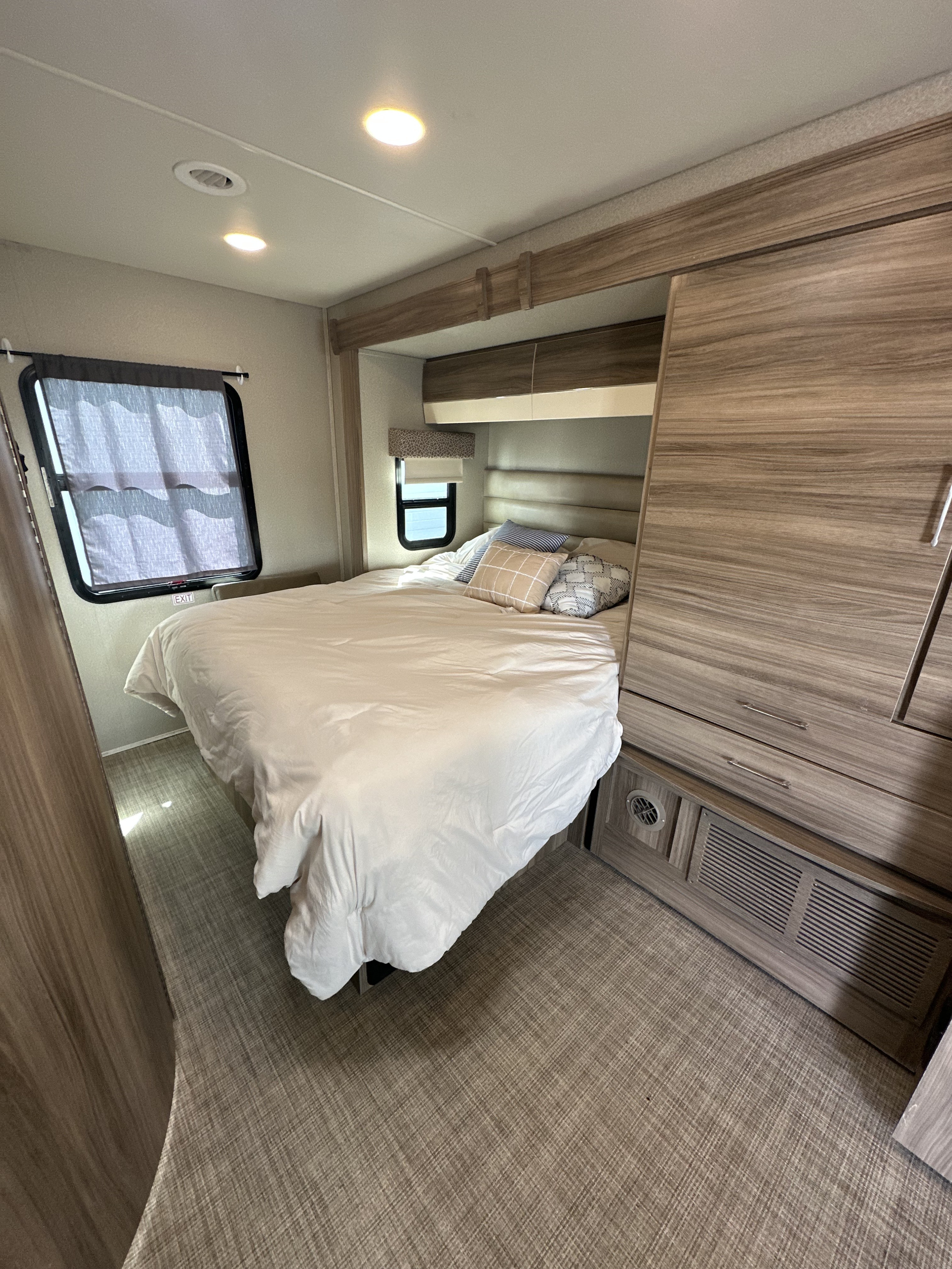 RV rental bedroom: A comfortable bed, windows, and light wood cabinetry within this compact mobile living space.. Jayco Melbourne 2018