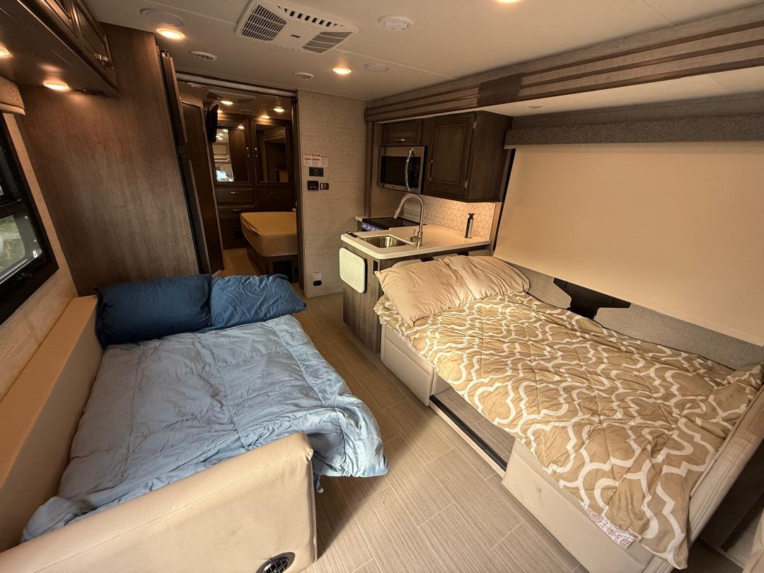RV rental interior featuring two comfortable beds, a kitchen, and an additional bedroom for versatile travel.. Forest River Entegra Esteem Jayco 2024
