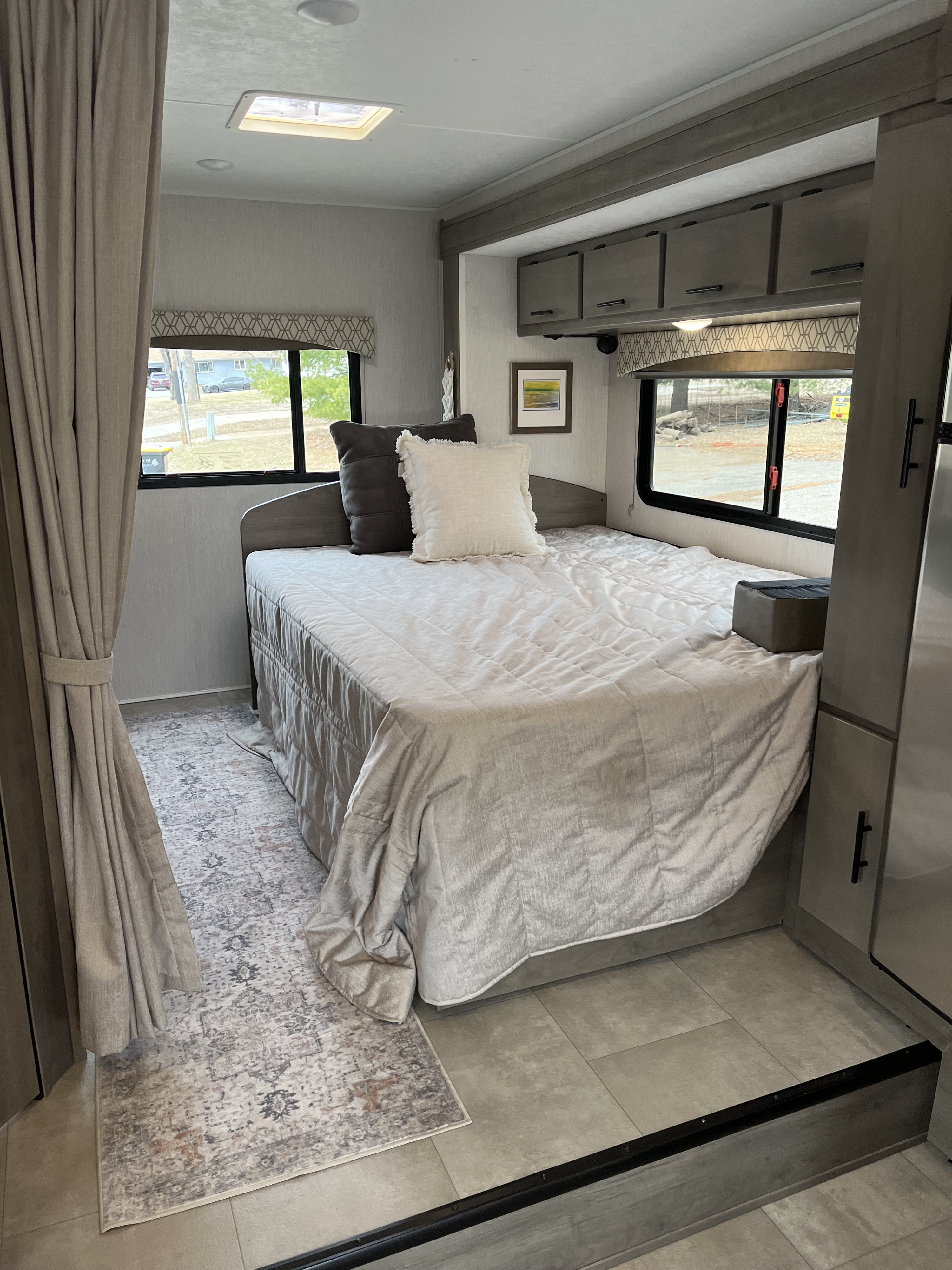 RV rental bedroom interior with cozy bed, modern cabinets, and large windows offering scenic views.. Coachmen Freelander 23FS 2021