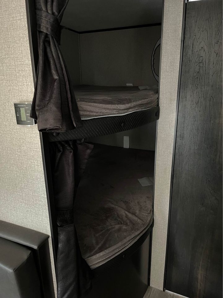 Cozy dark bunk beds with privacy curtains inside an RV rental, ready for your next adventure.. Jayco Jay Flight SLX 2022