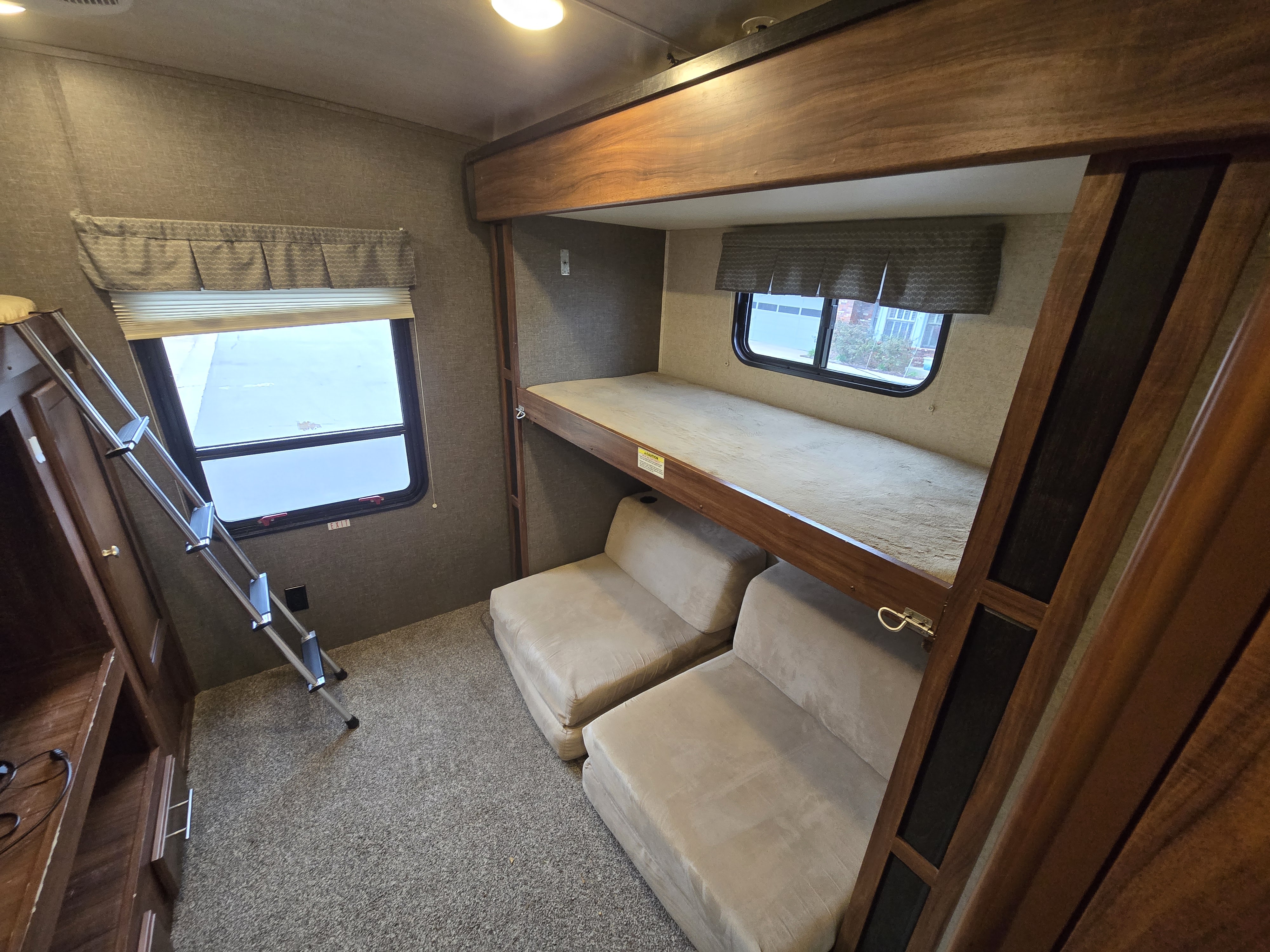RV rental bunk beds interior: includes a ladder, two versatile lower seats, and windows.. Heartland RVs Wilderness 2017