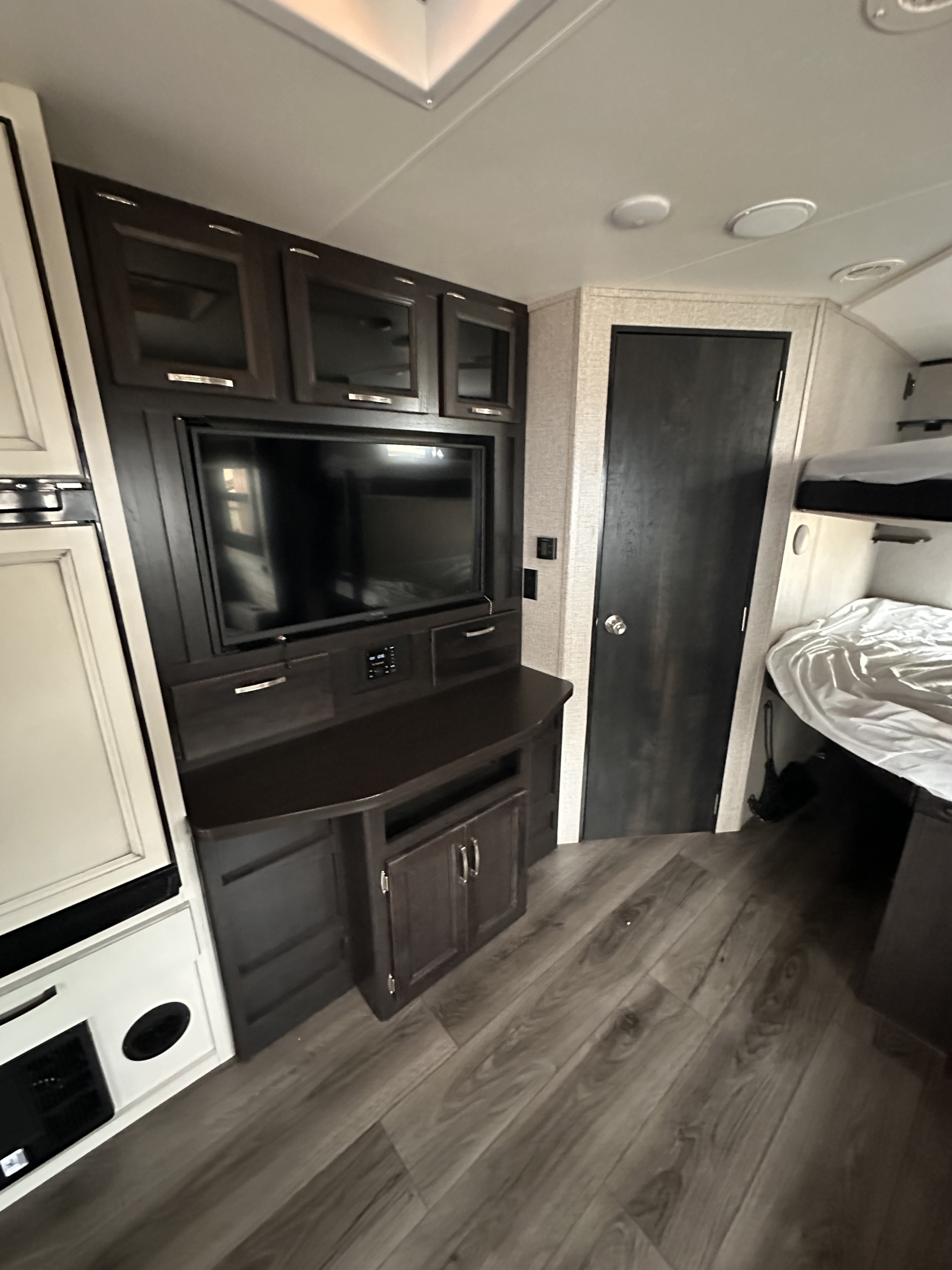 RV rental interior: cozy living space with TV entertainment center, built-in appliances, and bunk beds.. Jayco Jay Feather 2021