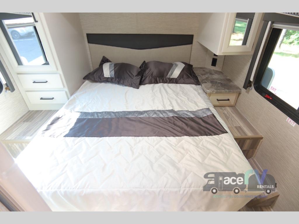 Cozy RV bedroom interior with a comfortable bed, storage, and natural light, perfect for your next RV rental adventure.. Thor Motor Coach Four Winds 2023