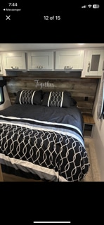 Cozy RV bedroom with comfortable bed, wood headboard & cabinets, perfect for your next rv rental adventure.. Keystone Fuzion 2020
