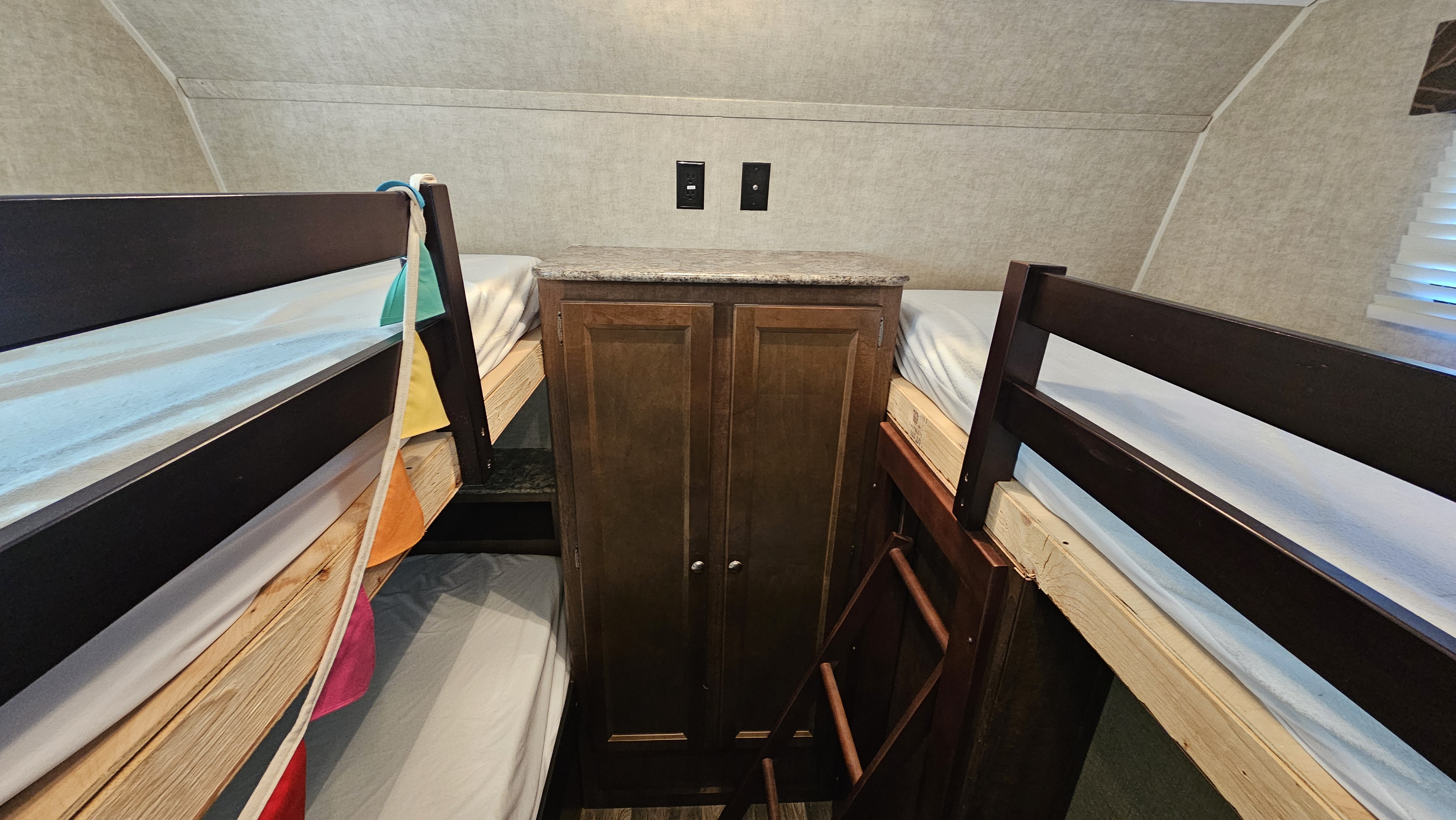 RV rental: Bunk beds flank a central storage cabinet with outlets, showing a cozy sleeping area.. Keystone RV Hideout 2016