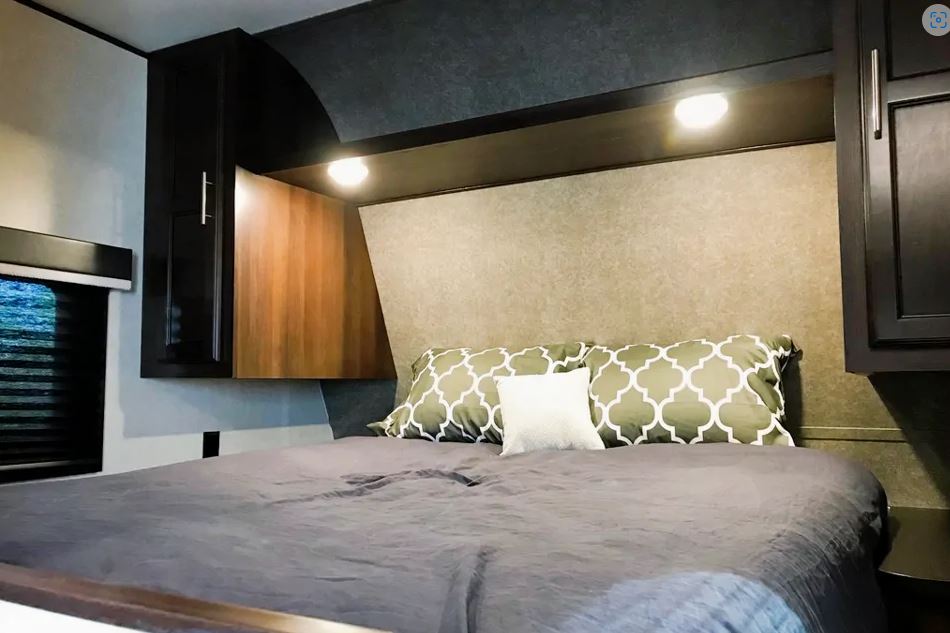 Cozy RV rental bedroom interior with a queen bed, overhead lighting, and ample storage cabinets. Perfect for travel.. Jayco Jay Flight 2020