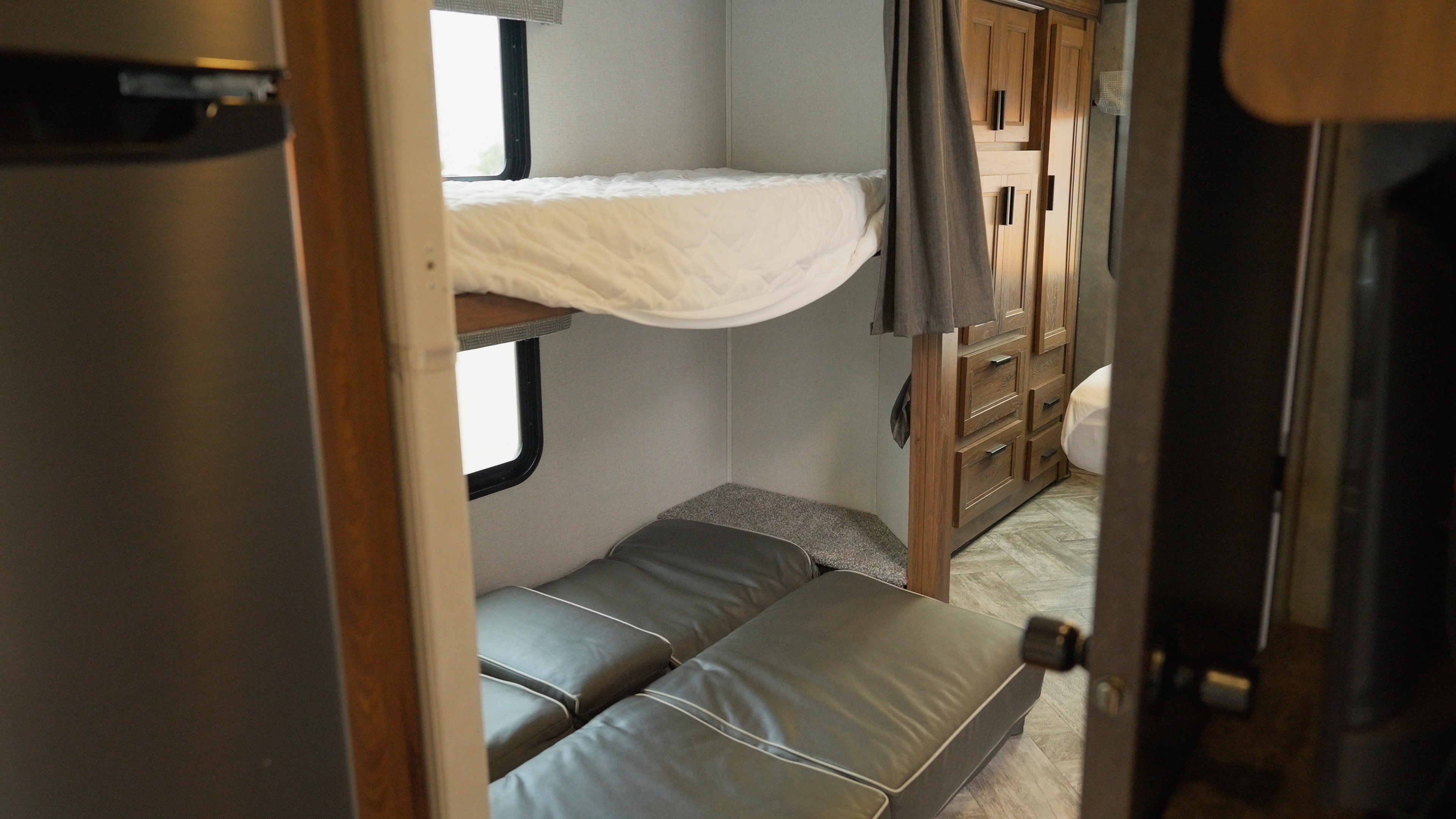 RV rental interior: cozy bunk beds with lower convertible seating/bed & ample storage cabinets.. Forest River Sunseeker 2024