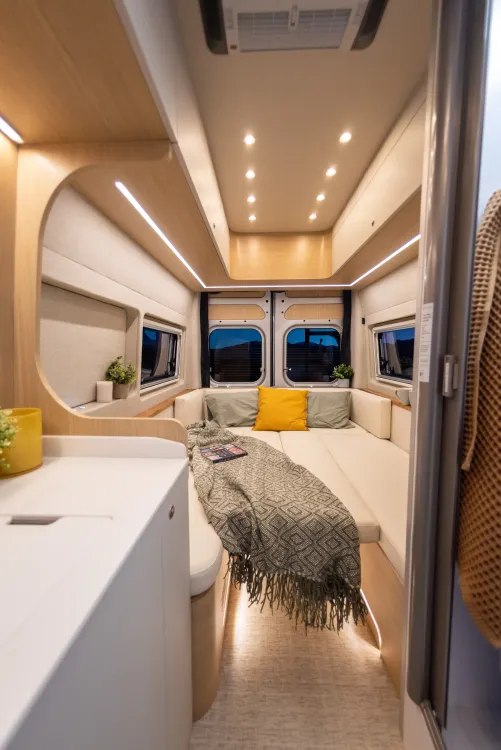 Experience mobile comfort! This modern RV rental interior features a cozy bed, ambient lighting, and smart storage.. Noovo Plus RL 2025