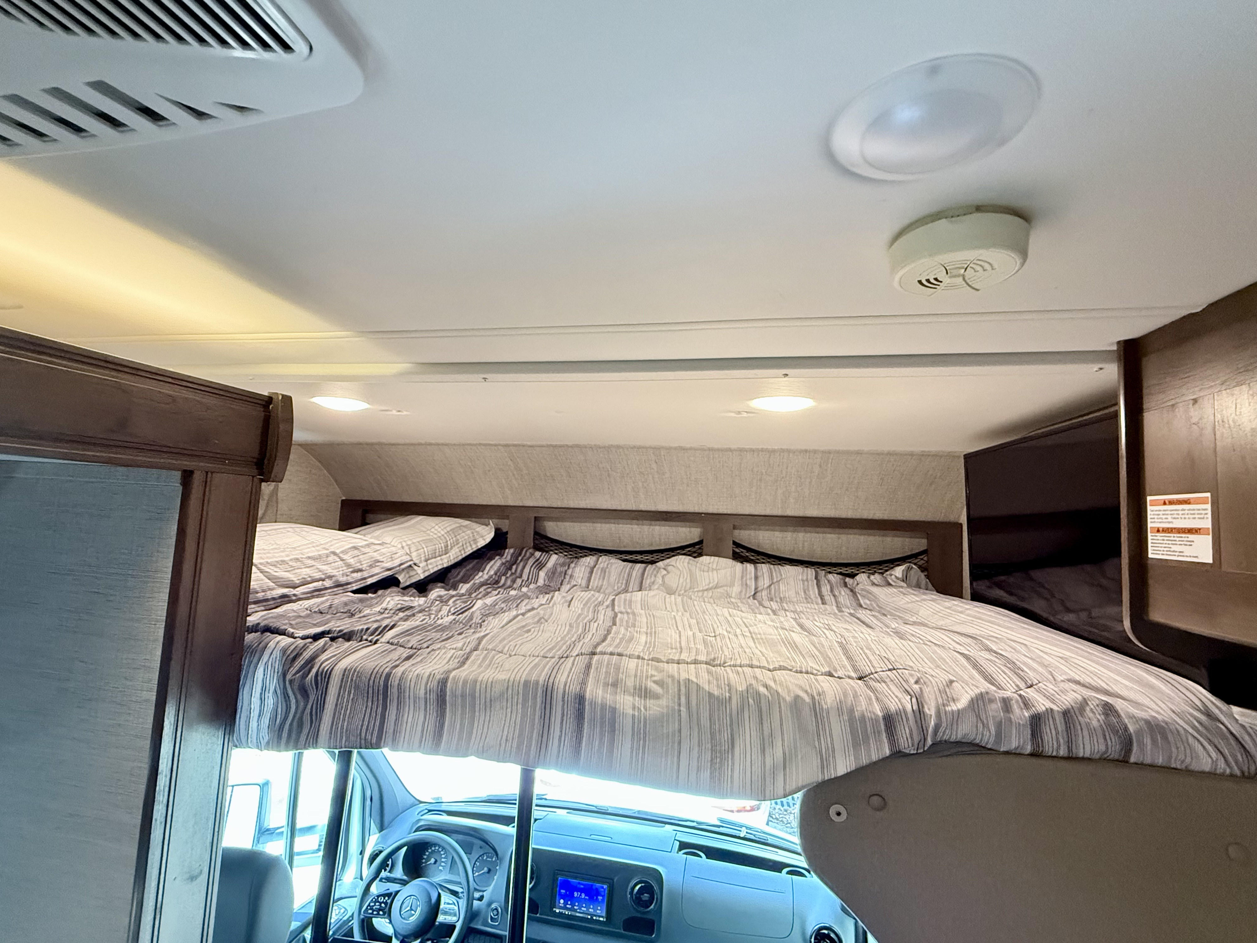 Spacious RV rental interior with a cozy cab-over bunk bed and visible cockpit.. Jayco Melbourne 2021