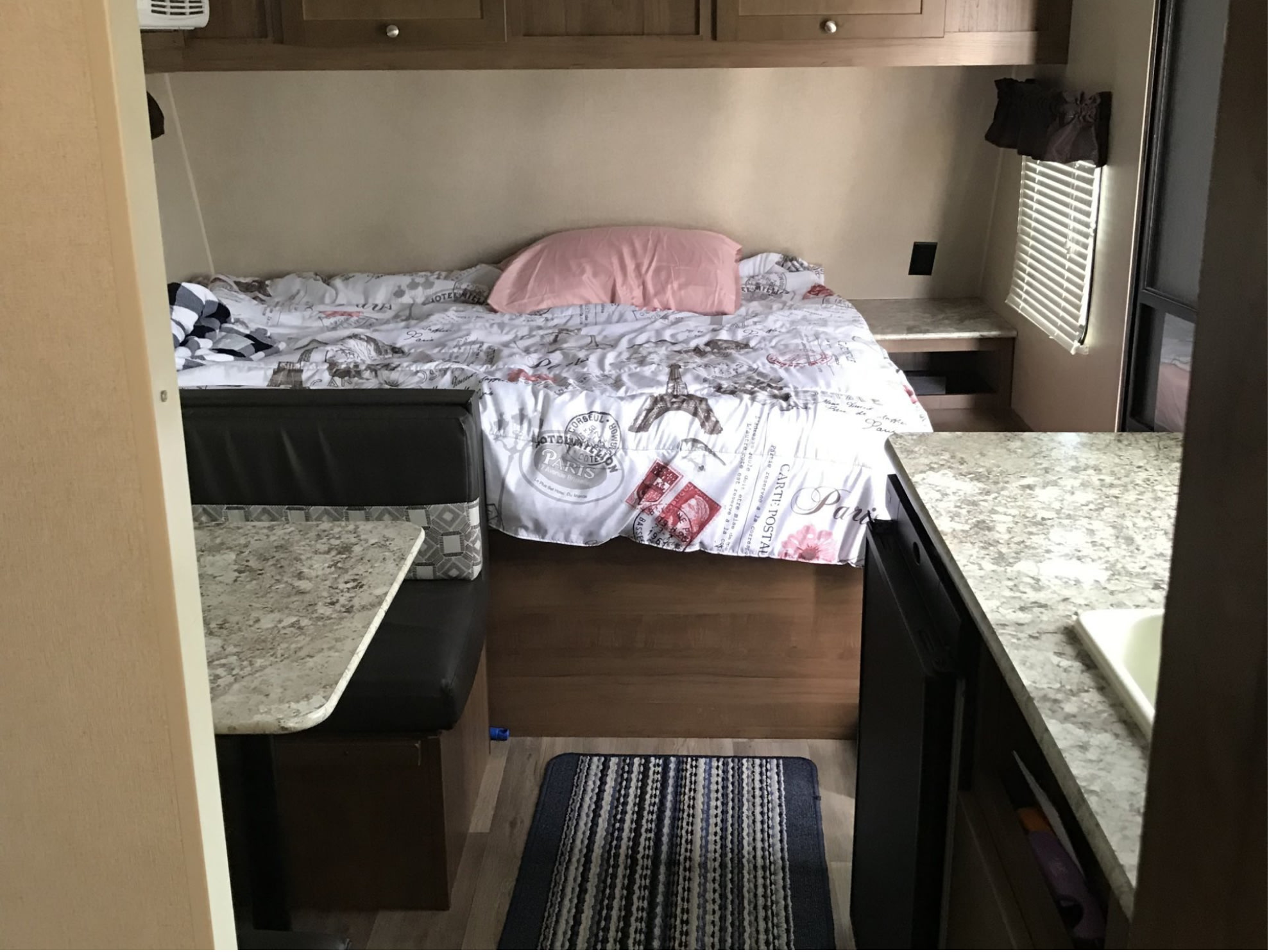 Cozy RV rental interior with a Paris-themed bed, a functional dinette, and a compact kitchen area.. Aspen Trail Aspen Trail Trailer 2017