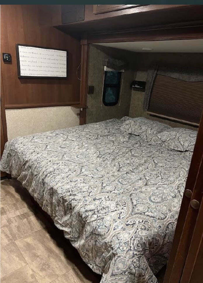 Spacious rv rental bedroom with a comfy queen bed and stylish paisley comforter, offering a cozy retreat.. Forest River Georgetown 2016