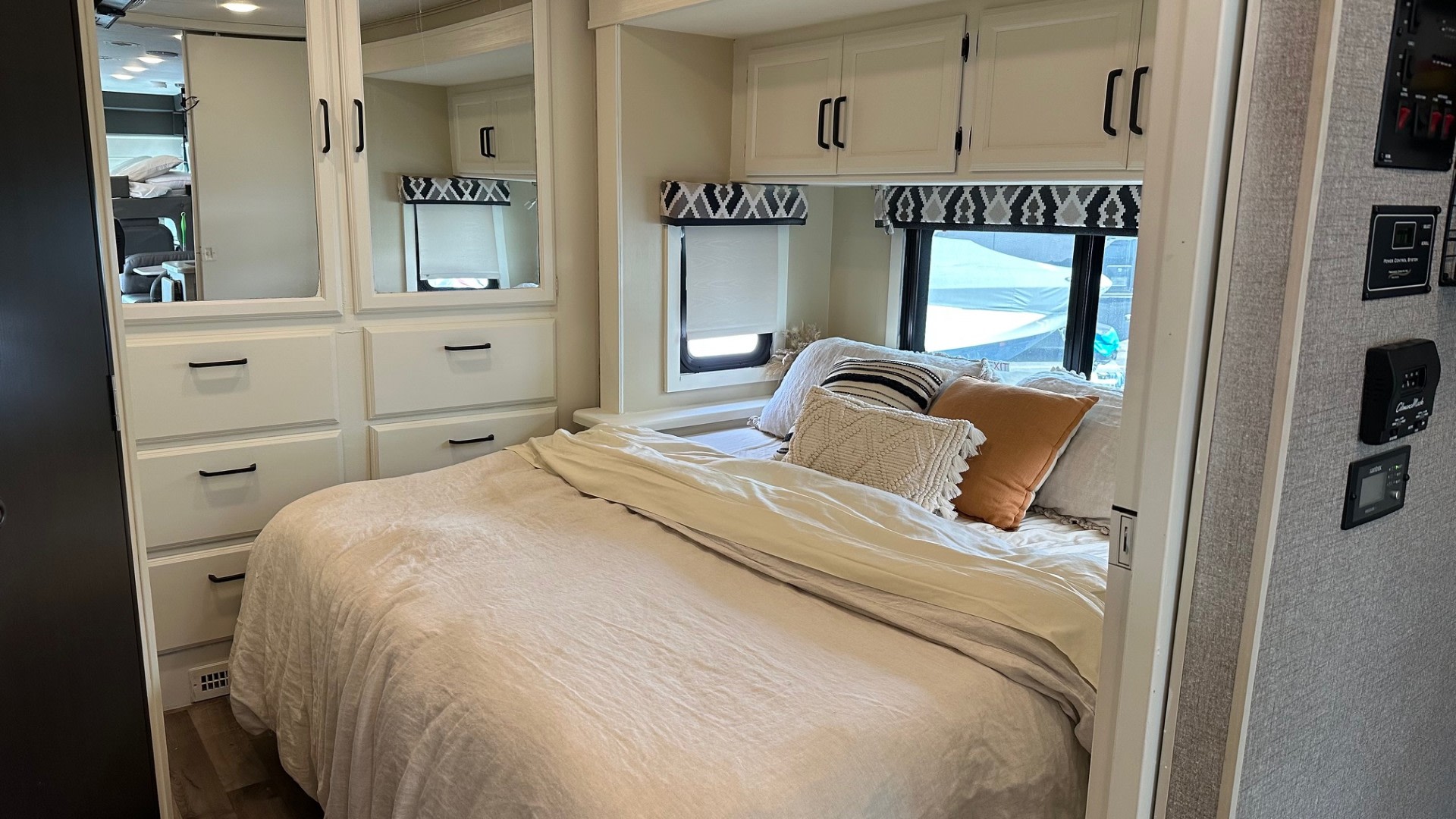 Cozy RV rental bedroom with comfy bed, overhead storage, mirrored wardrobe, and windows.. Jayco Alante 2021