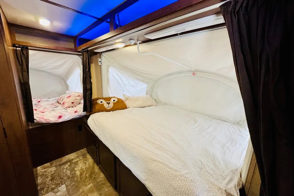 Interior of an **rv rental** showing two pop-up beds with white canvas walls & cozy bedding, ready for your adventure.. Jayco Jay Feather 2018
