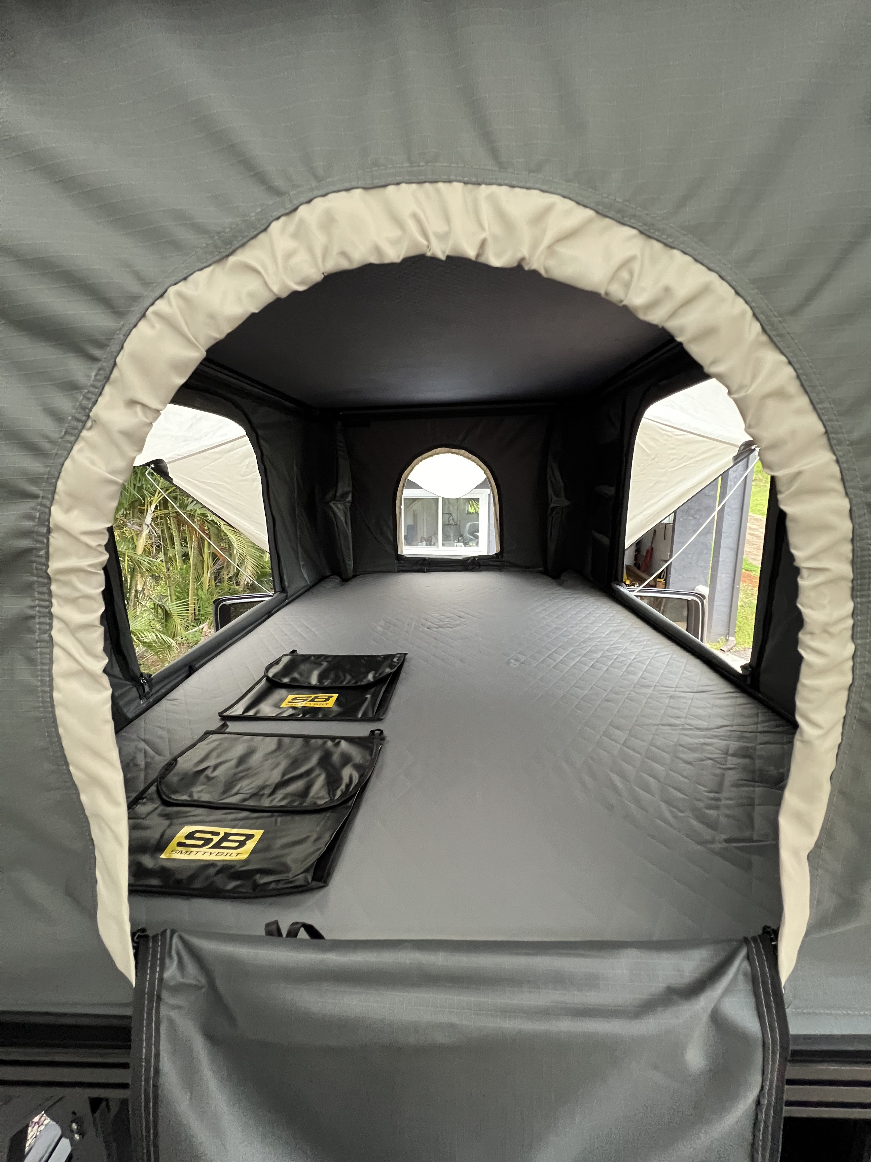 Spacious interior of a rooftop tent, ideal for your next rv rental adventure. Features quilted mattress, storage pouches, and views.. Toyota Trailfinder 2016