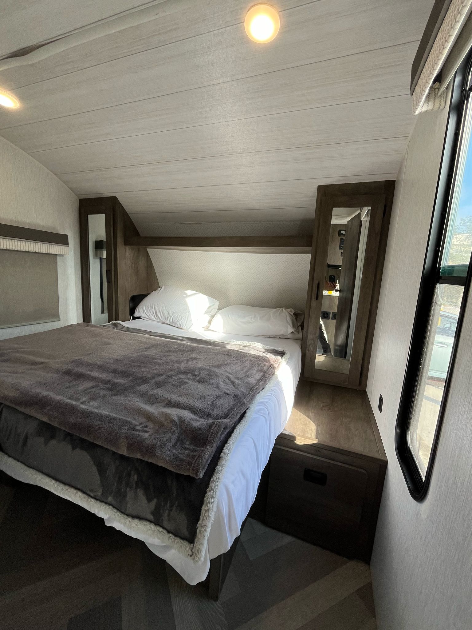 Comfortable RV rental bedroom with a cozy bed, ample storage, and natural light from the windows.. Forest River Salem Cruise Lite 2022