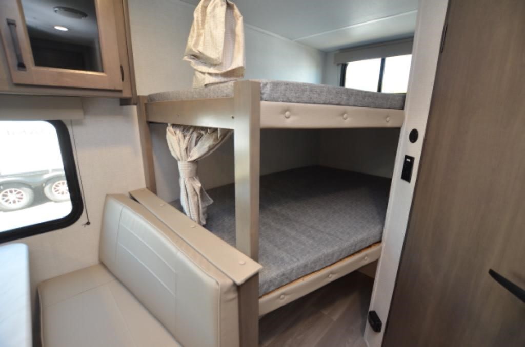 RV rental interior features bunk beds, dinette seating, and overhead cabinets. Cozy, compact space for your next family road trip.. Grand Design Transcend XPLOR 26BHX 2025