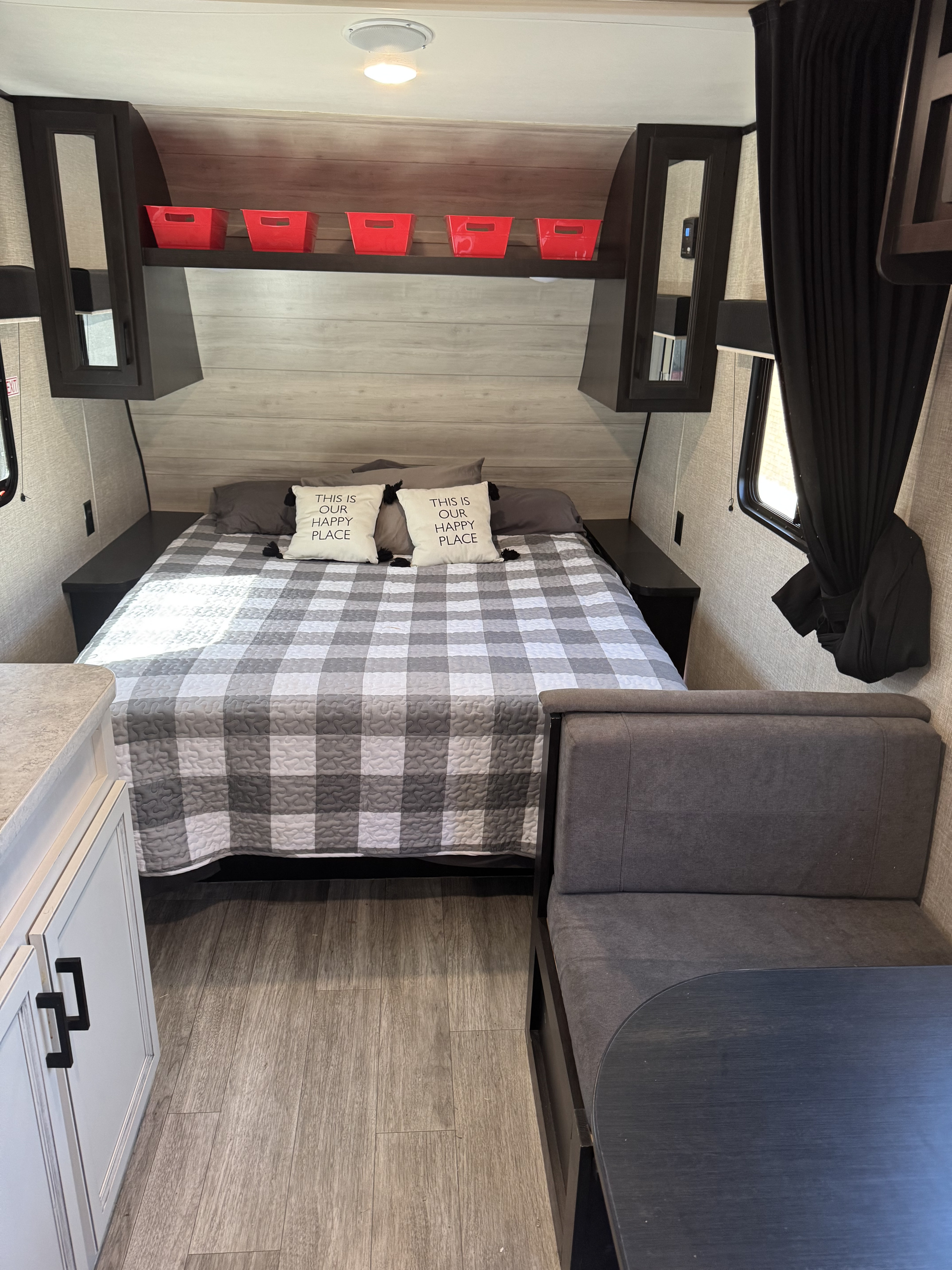 Inside an RV rental: a cozy bedroom with plaid bedding, overhead storage, and a dinette. Ready for comfortable adventures.. Jayco Jay Flight SLX 2022