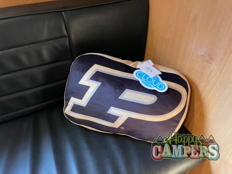 A Purdue 'P' Cloud Pillow rests on a black padded RV rental bench, ready for comfy travel.. Old School 820FTG 2023