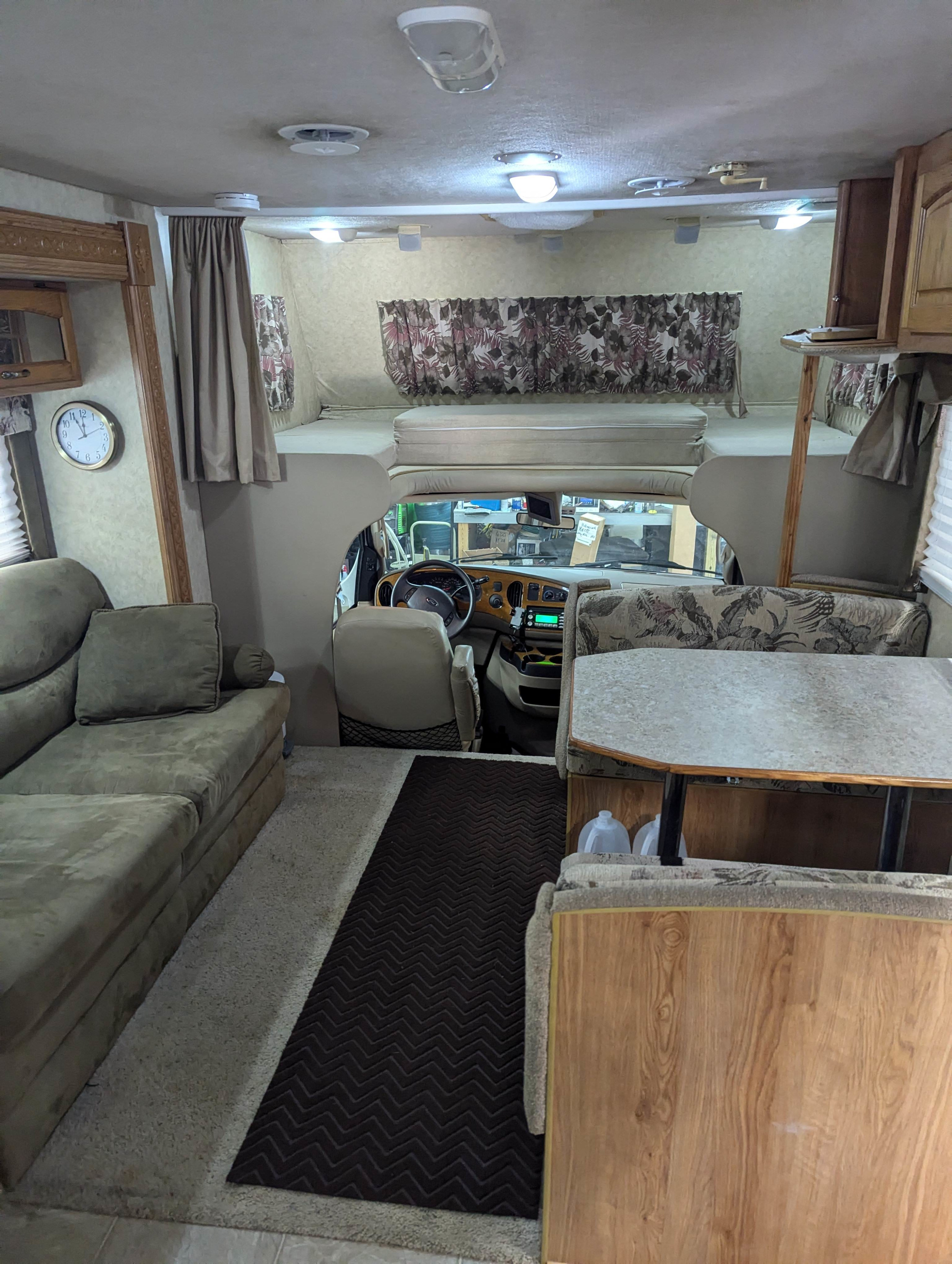 Spacious RV rental interior with comfortable sofa, dining booth, and elevated bunk bed.. Jayco Greyhawk 2006