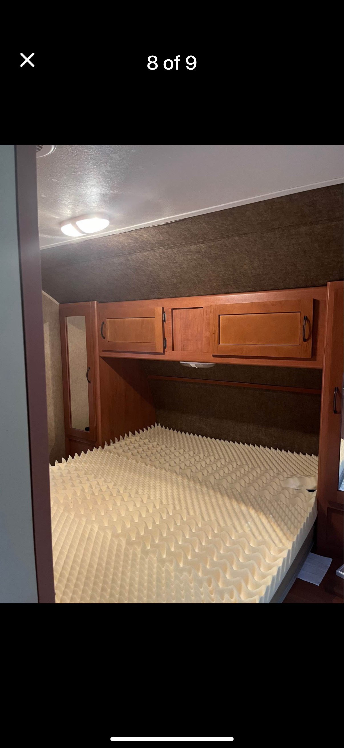 RV rental bedroom: Cozy space with egg crate mattress topper, wood cabinets, and mirror. Comfortable sleeping area.. Forest River Cherokee 2015