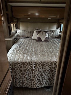 Experience comfortable travel! This cozy RV rental bedroom offers a queen bed, decorative bedding, and ample storage for trips.. Thor Gemini 2018