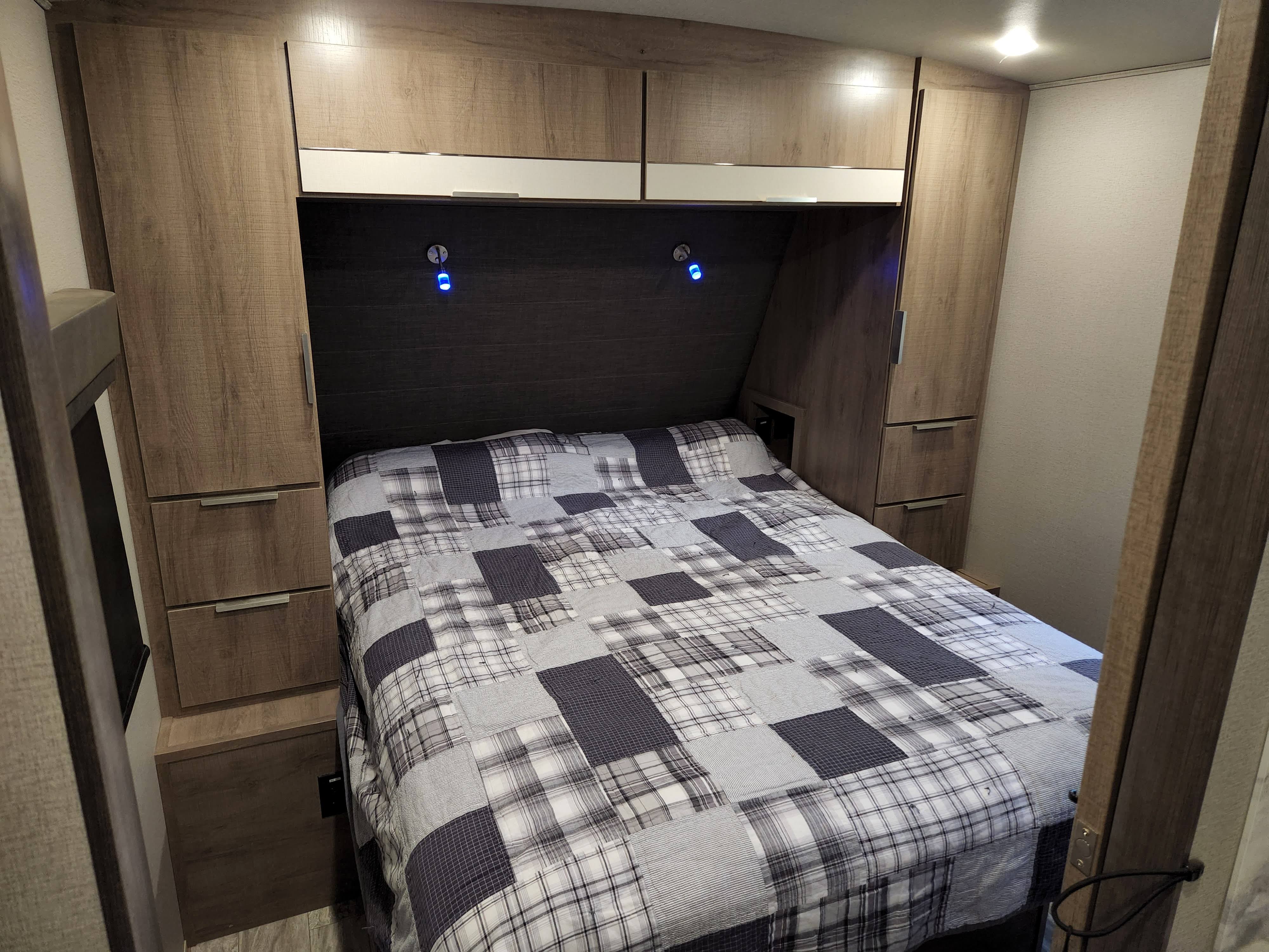 Cozy RV rental bedroom with built-in storage, a comfortable bed, and accent lighting.. Grand Design Imagine 2021