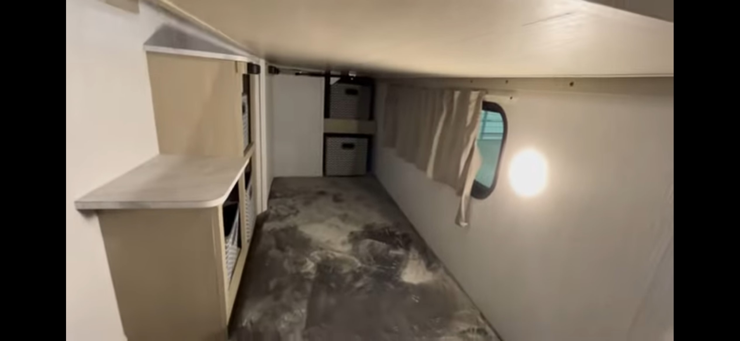 RV rental interior: compact bunk/storage area with built-in shelves, bins, window, and overhead light.. Forest River Salem 2024