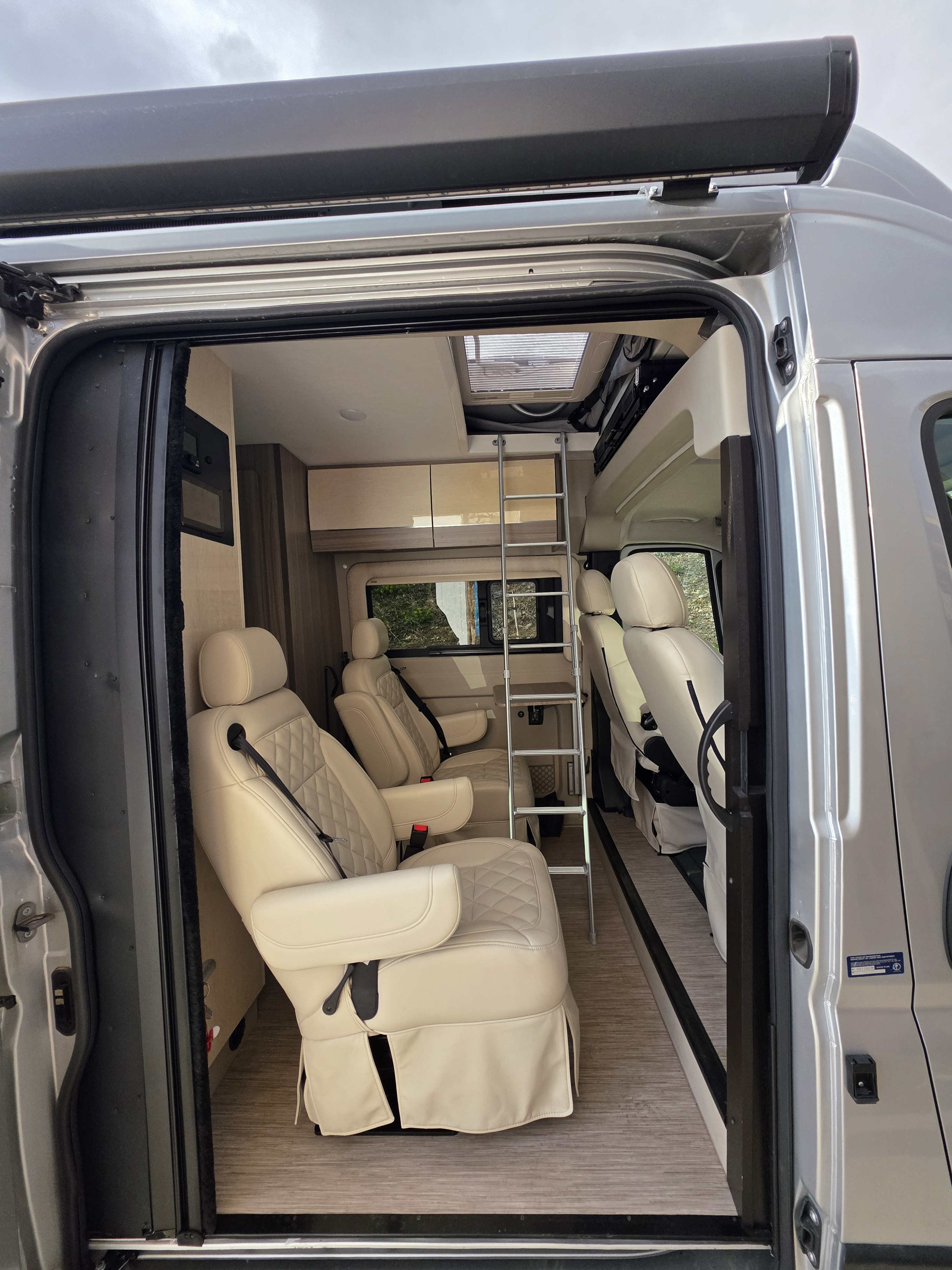 Spacious RV rental interior with comfy quilted seats, ladder to bunk, and modern design.. Jayco Swift 2024
