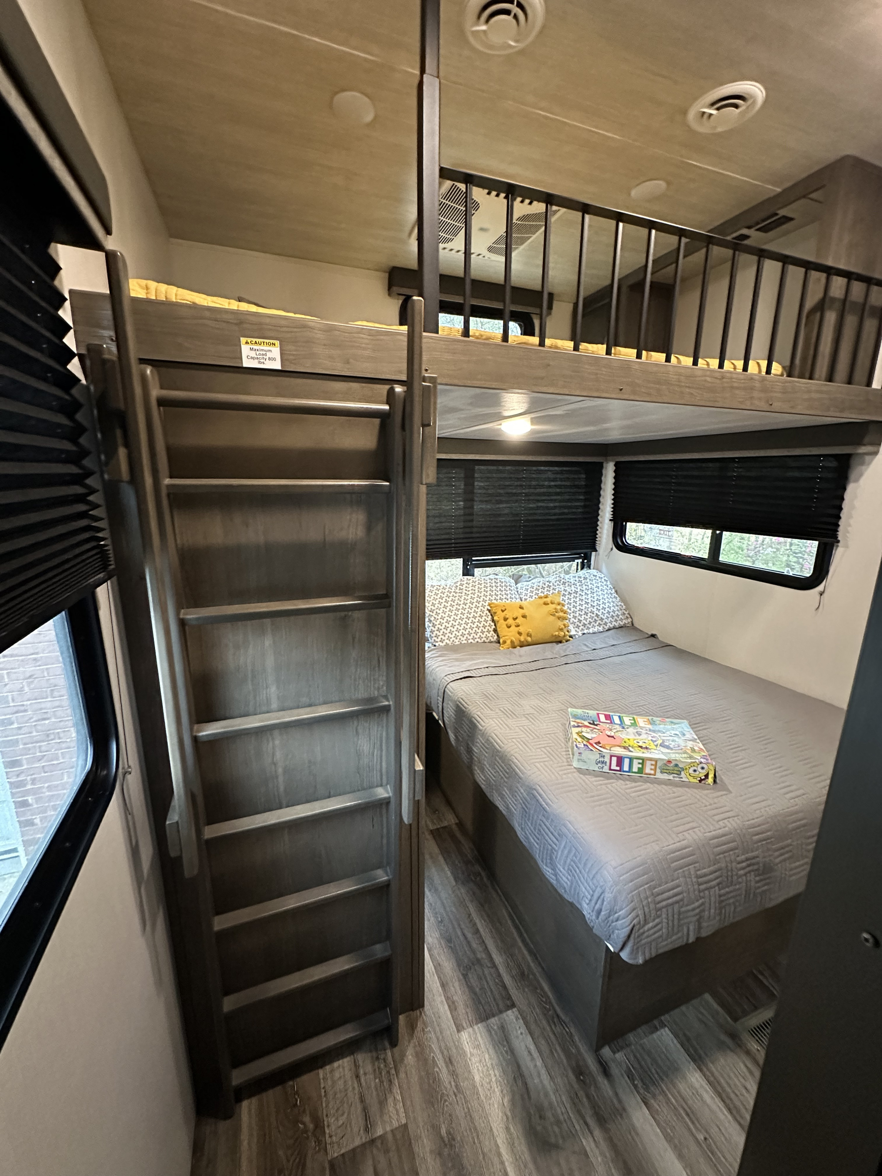 RV rental with modern interior: cozy lower bed, upper bunk with ladder, ideal for family trips.. Keystone RV Cougar 2021