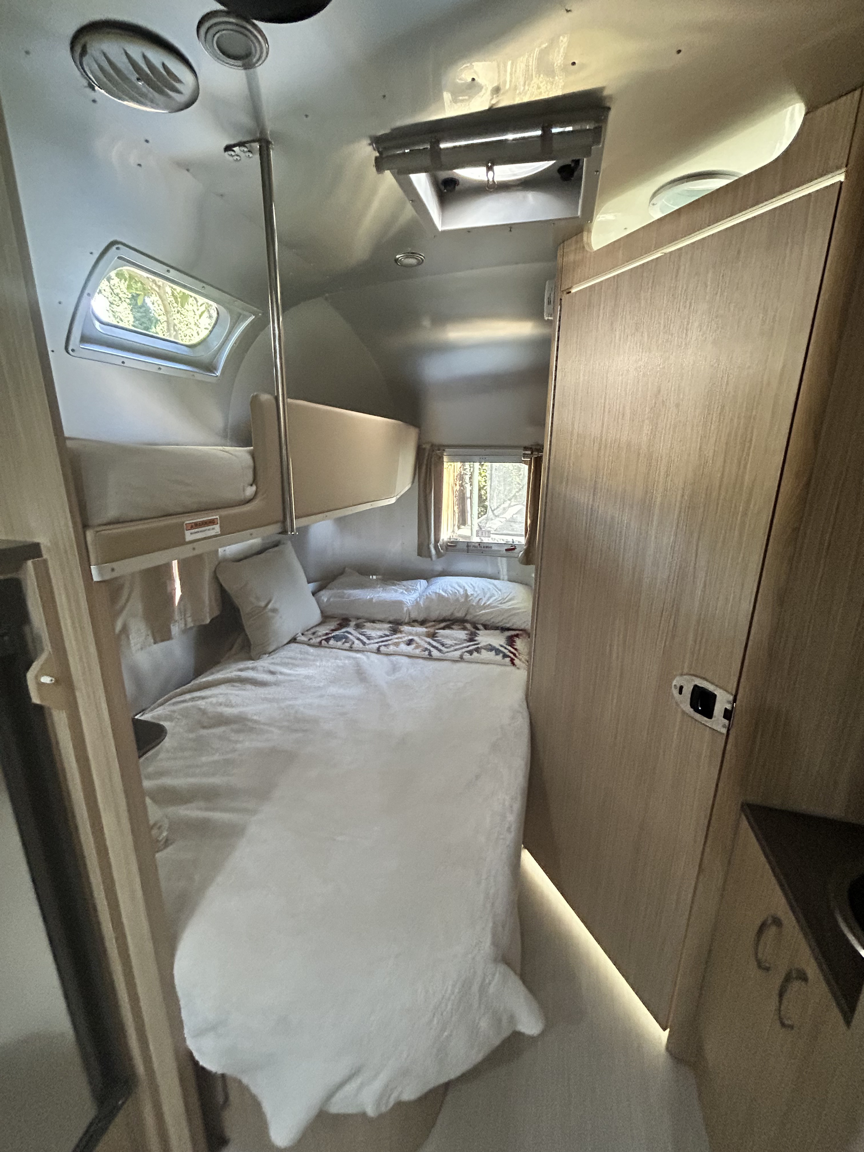 Experience a comfortable rv rental. This compact interior features cozy bunk beds, a lower bed, and modern finishes.. Airstream Flying Cloud 2017