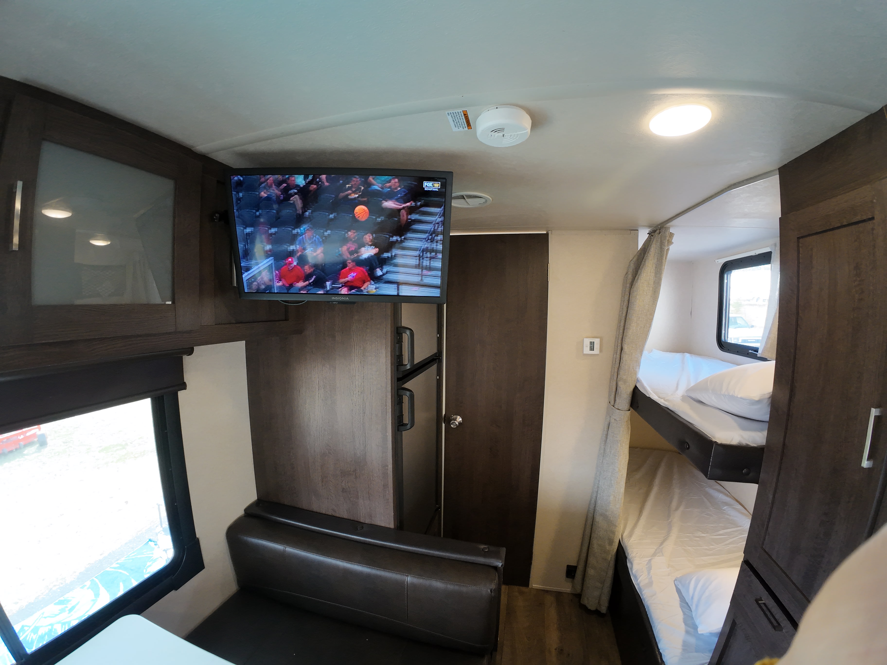 This RV rental interior offers a TV, comfy bunk beds, and dinette, creating a functional and cozy living space.. Forest River Salem Cruise Lite 2018