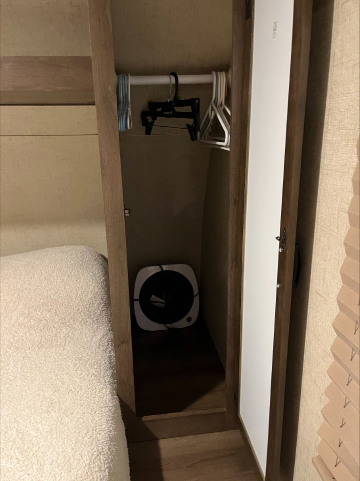 RV rental bedroom closet: hangers ready, a compact fan for comfort next to a cozy bed.. KZ Connect 2018