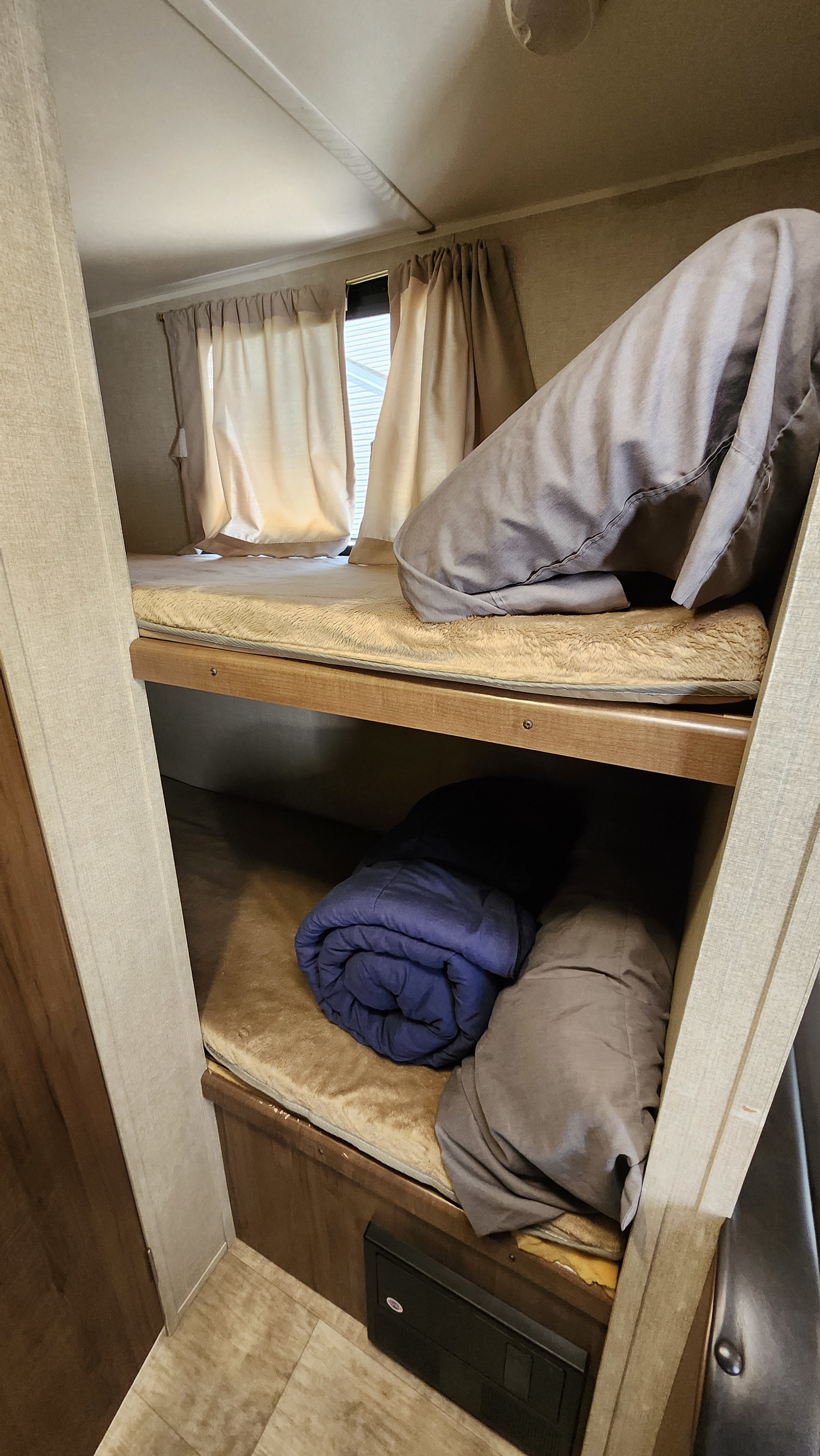 Comfortable bunk beds within an RV rental, featuring soft blankets and curtains. Ideal for a cozy travel stay.. Gulf Stream Ameri-Lite Super Lite 2018